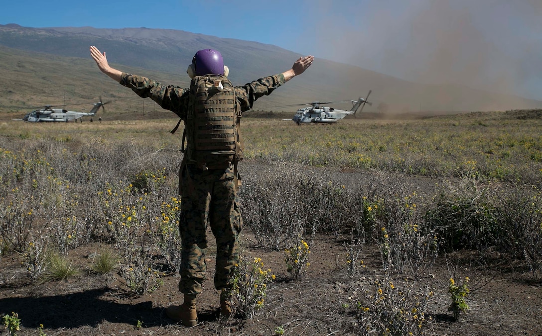 Petty Officer 3rd Class Hayes Barber, from New Orleans, Louisiana, signals where simulated casualties lie Jan. 19 during a mass casualty drill as part of Lava Viper 15.1-2 at Pohakuloa Training Area, Hawaii, Hawaii. The purpose of the drill was to speed up future recoveries of casualties. Barber is a hospital corpsman with Marine Wing Support Detachment 24, Marine Aircraft Group 24, 1st Marine Aircraft Wing, III Marine Expeditionary Force. The helicopters are with Heavy Marine Helicopter Squadron 463, MAG-24. 