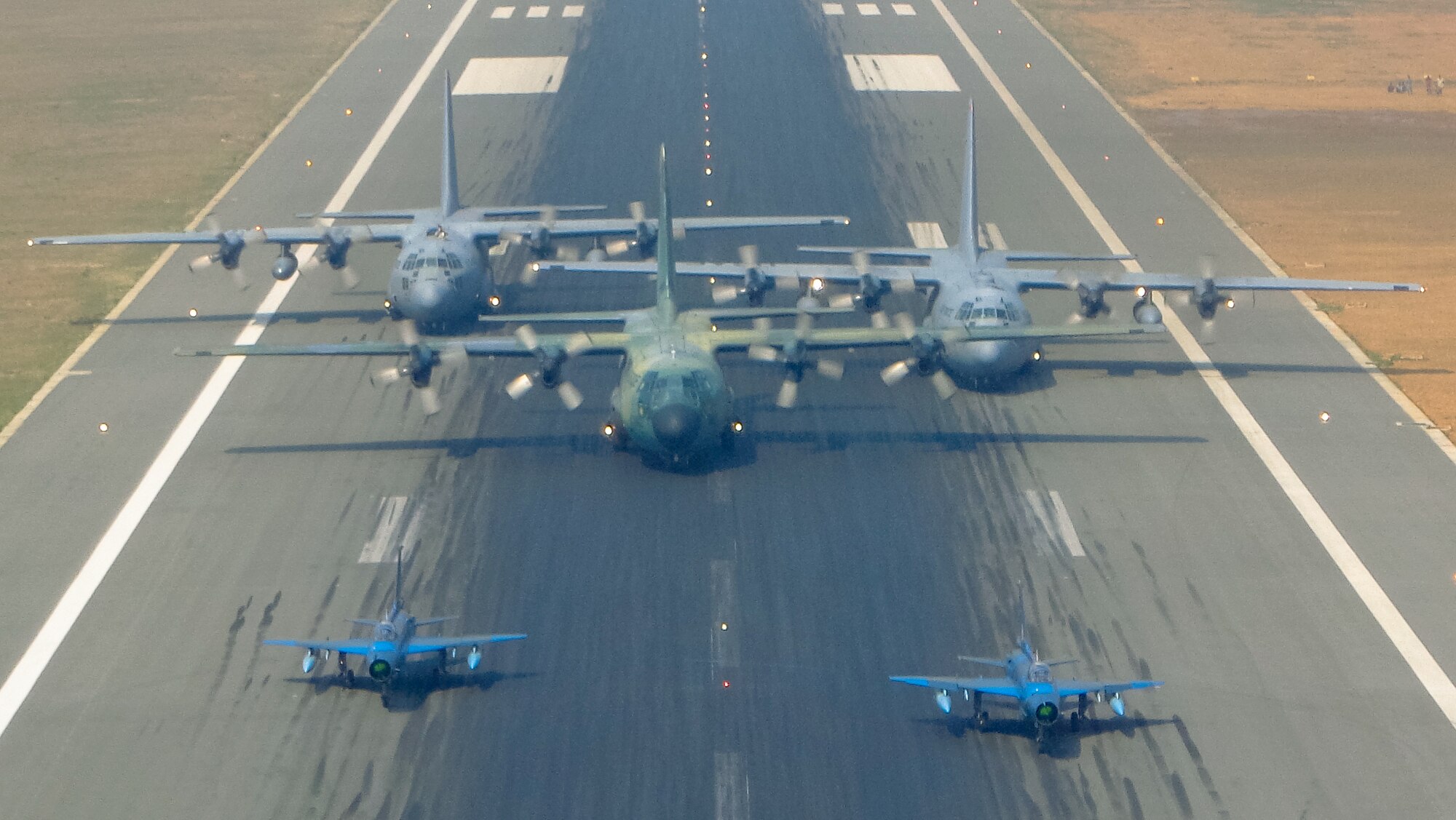 Two Bangladesh F-7BG Defenders, a BAF C-130B Hercules, and two U.S. Air Force C-130H Hercules aircraft prepare to take off from BAF Base Bangabandhu,  Bangladesh, during Exercise COPE SOUTH Jan. 28, 2015. The U.S. C-130H is assigned to the 374th Airlift Wing, Yokota Air base, Japan; the BAF F-7BGs are assigned to 5th Squadron and the BAF C-130B is assigned to 101st Special Flying Unit at BAF Base Bangabandhu. COPE SOUTH is a Pacific Air Forces-sponsored, bilateral tactical airlift exercise conducted in Bangladesh, with a focus on cooperative flight operations, day and night low-level navigation, tactical airdrop, and air-land missions as well as subject-matter expert exchanges in the fields of operations, maintenance and rigging disciplines. (Courtesy photo by Bangladesh Air Force)