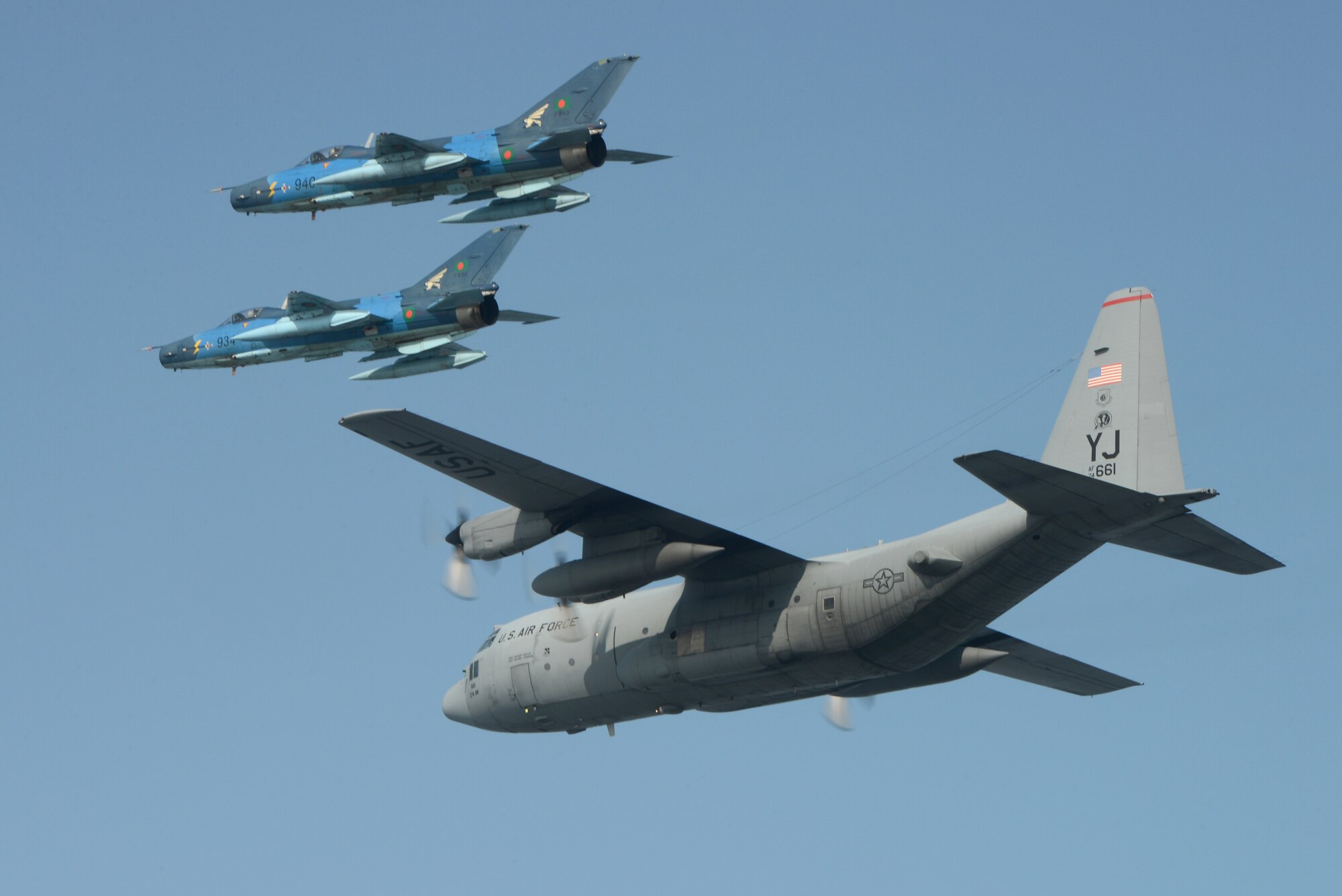 Two Bangladesh Air Force F-7BG Defenders from 5th Squadron, BAF Base Bangabandhu, escort a U.S. C-130H Hercules from the 374th Airlift Wing, Yokota Air Base, Japan, during Exercise COPE SOUTH near Kishoreganj, Bangladesh, Jan. 28, 2015. COPE SOUTH is a Pacific Air Forces-sponsored, bilateral tactical airlift exercise conducted in Bangladesh, with a focus on cooperative flight operations, day and night low-level navigation, tactical airdrop, and air-land missions as well as subject-matter expert exchanges in the fields of operations, maintenance and rigging disciplines. (U.S. Air Force photo by 1st Lt. Jake Bailey/Released)