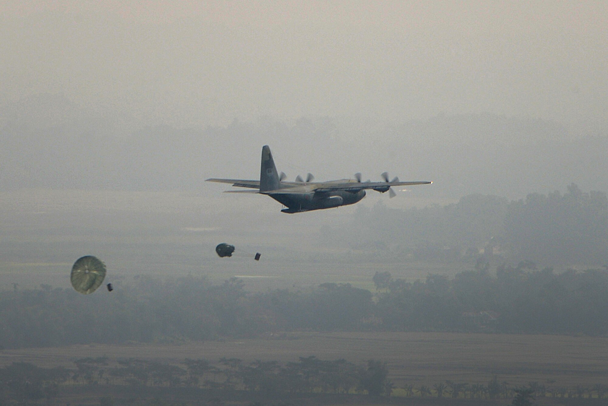 A Bangladesh Air Force C-130B assigned to 101st Special Flying Unit, BAF Base Bangabandhu, drops two U.S. Air Force low-cost, low-altitude airdrop over a drop zone at Exercise COPE SOUTH near Sylhet, Bangladesh, Jan. 28, 2015. COPE SOUTH is a Pacific Air Forces-sponsored, bilateral tactical airlift exercise conducted in Bangladesh, with a focus on cooperative flight operations, day and night low-level navigation, tactical airdrop, and air-land missions as well as subject-matter expert exchanges in the fields of operations, maintenance and rigging disciplines. (U.S. Air Force photo by 1st Lt. Jake Bailey/Released)