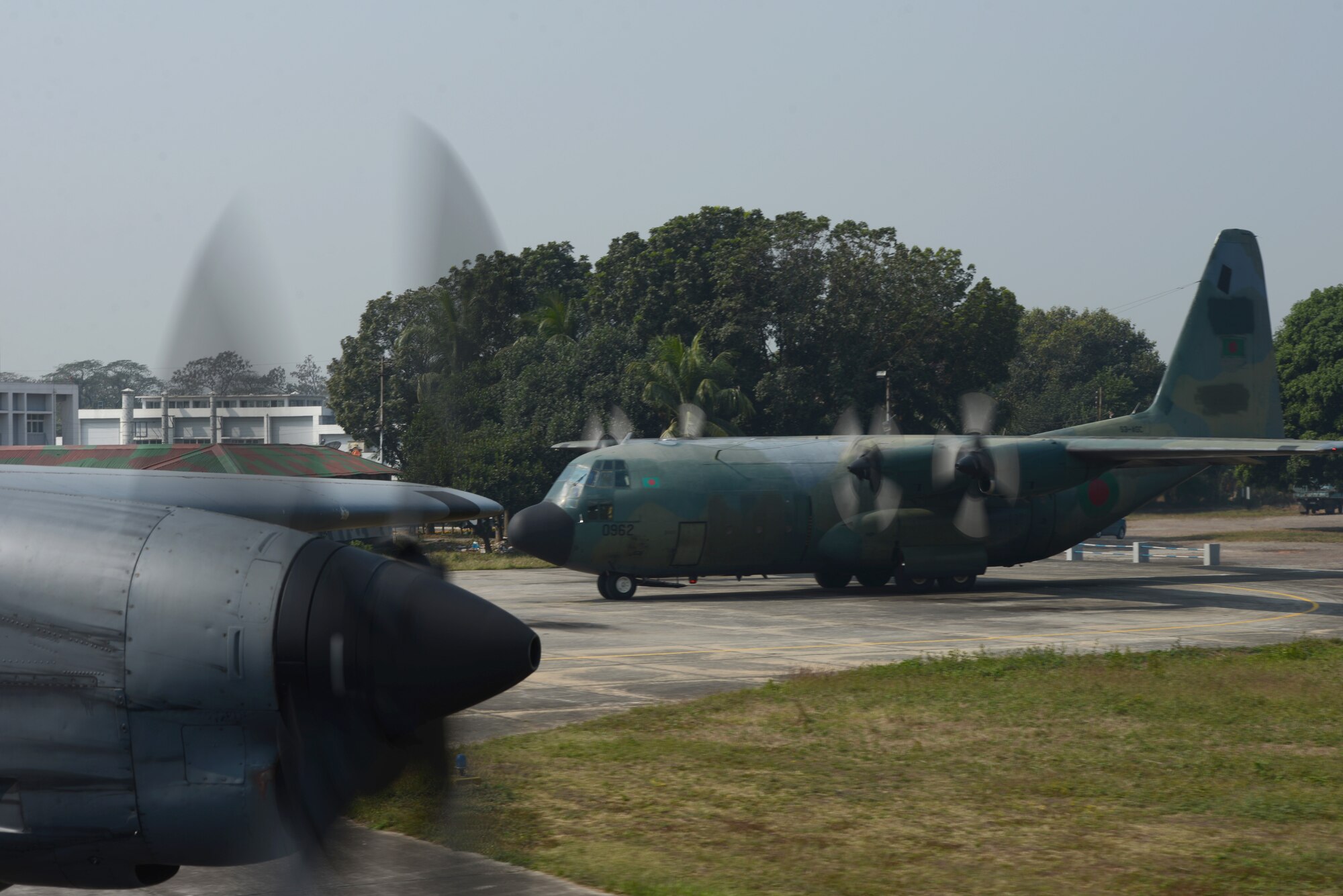 A C-130H rom the 374th Airlift Wing, Yokota Air Base, Japan, and a Bangladesh Air Force C-130B from the 101st Special Flying Unit prepare to take off for a mission during Exercise COPE SOUTH at BAF Base Bangabandhu,  Bangladesh, Jan. 28, 2015. COPE SOUTH is a Pacific Air Forces-sponsored, bilateral tactical airlift exercise conducted in Bangladesh, with a focus on cooperative flight operations, day and night low-level navigation, tactical airdrop, and air-land missions as well as subject-matter expert exchanges in the fields of operations, maintenance and rigging disciplines. (U.S. Air Force photo by 1st Lt. Jake Bailey/Released)