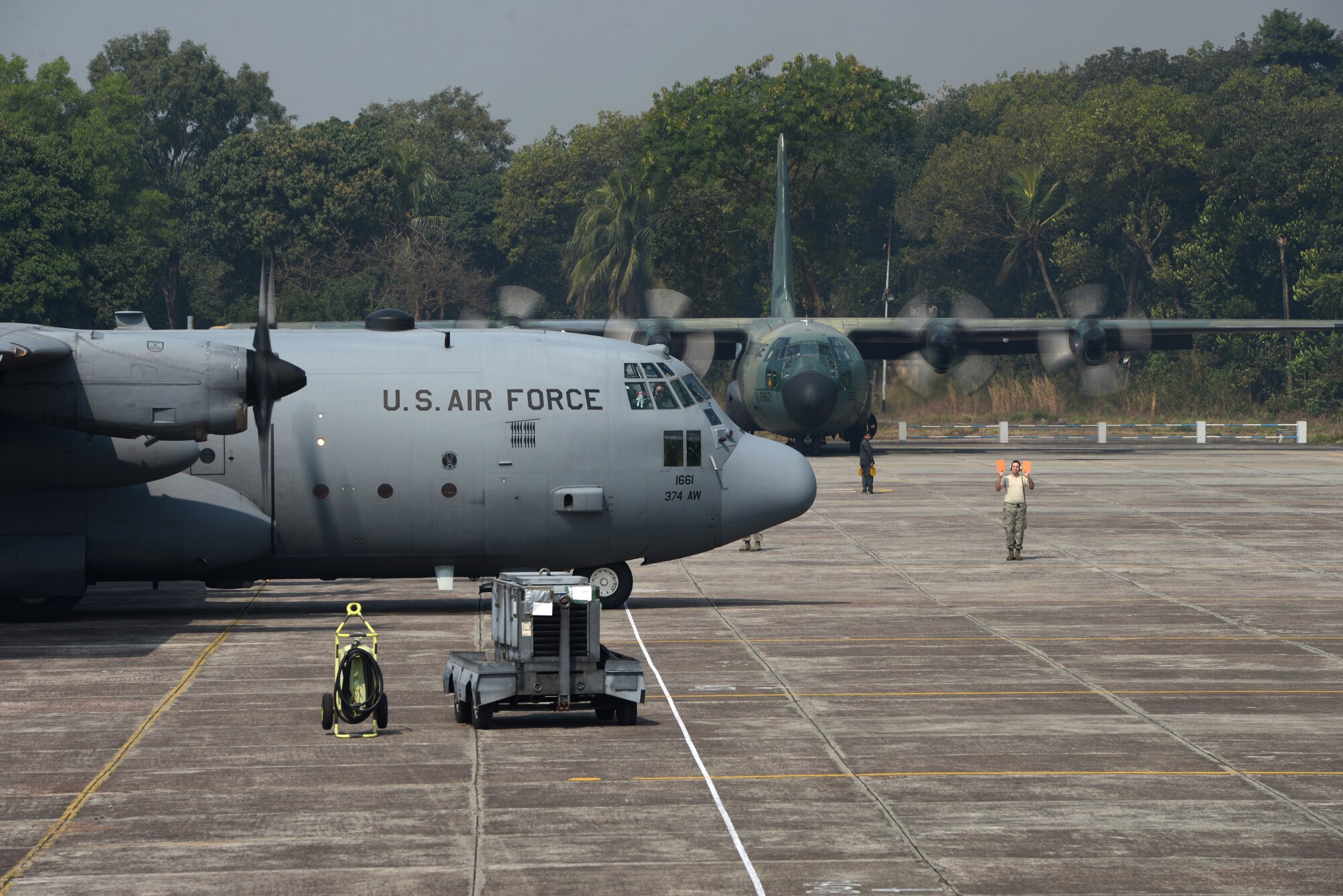 A C-130H rom the 374th Airlift Wing, Yokota Air Base, Japan, and a Bangladesh Air Force C-130B from the 101st Special Flying Unit prepare to take off for a mission during Exercise COPE SOUTH at BAF Base Bangabandhu,  Bangladesh, Jan. 28, 2015. COPE SOUTH is a Pacific Air Forces-sponsored, bilateral tactical airlift exercise conducted in Bangladesh, with a focus on cooperative flight operations, day and night low-level navigation, tactical airdrop, and air-land missions as well as subject-matter expert exchanges in the fields of operations, maintenance and rigging disciplines. (U.S. Air Force photo by 1st Lt. Jake Bailey/Released)