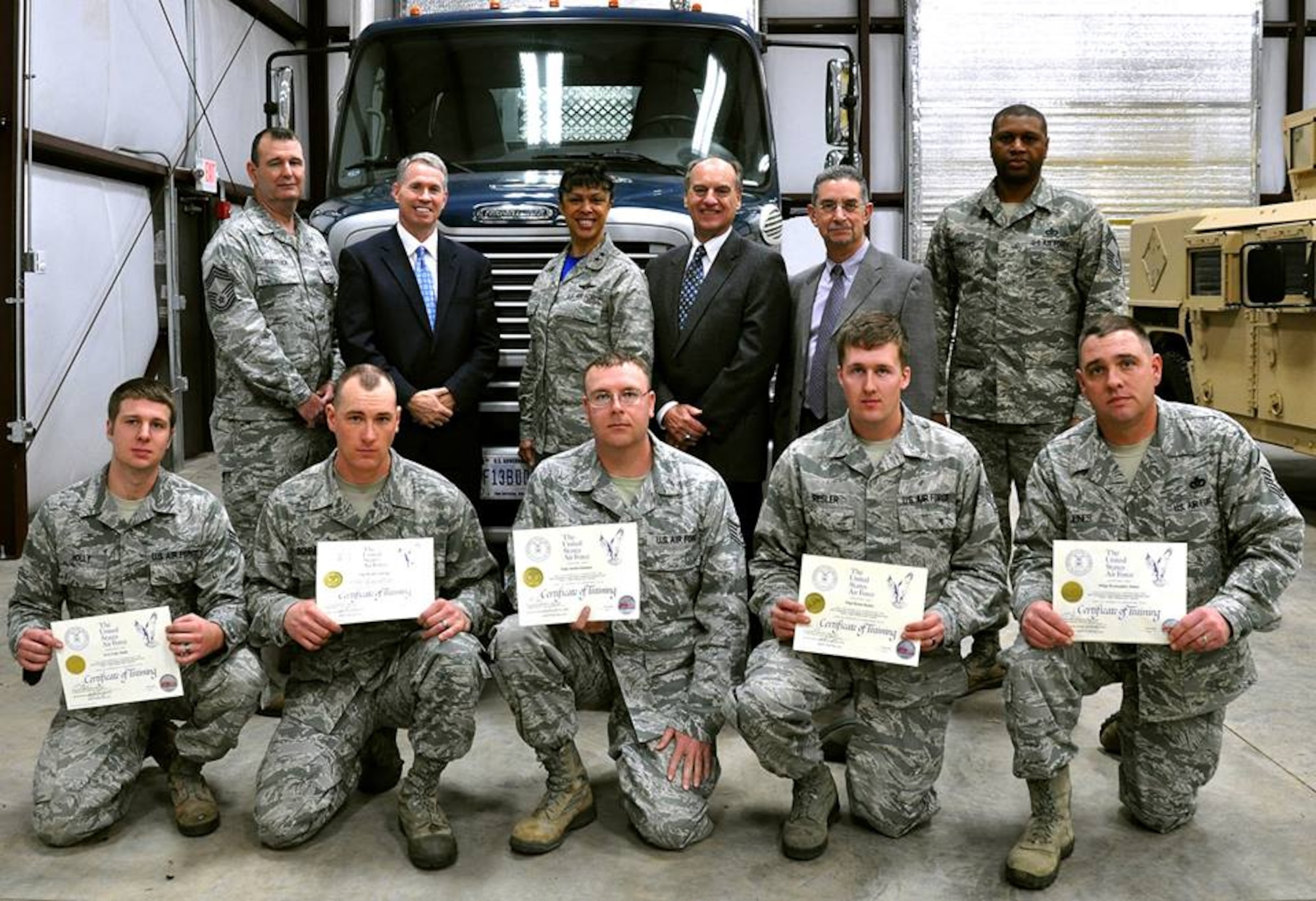 Back row, left to right: Chief Master Sgt. Trevor Shattuck, AFCEC Reserve Career Field Manager; Brad Bentley, Truckload Carriers Association and Professional Truck Driver Institute President; Maj. Gen. Stayce Harris, 22nd Air Force Commander, Dobbins Air Reserve Base, Georgia; Jack Duke, PTDI board member; David Money, PTDI chairman of the board; and Chief Master Sgt. Leonard Howard, 622nd Civil Engineer Group Expeditionary Combat Support Training and Certification Center Commandant, pose with recent graduates of the Air Force Tractor Trailer Training, or 3T, program at Dobbins ARB.