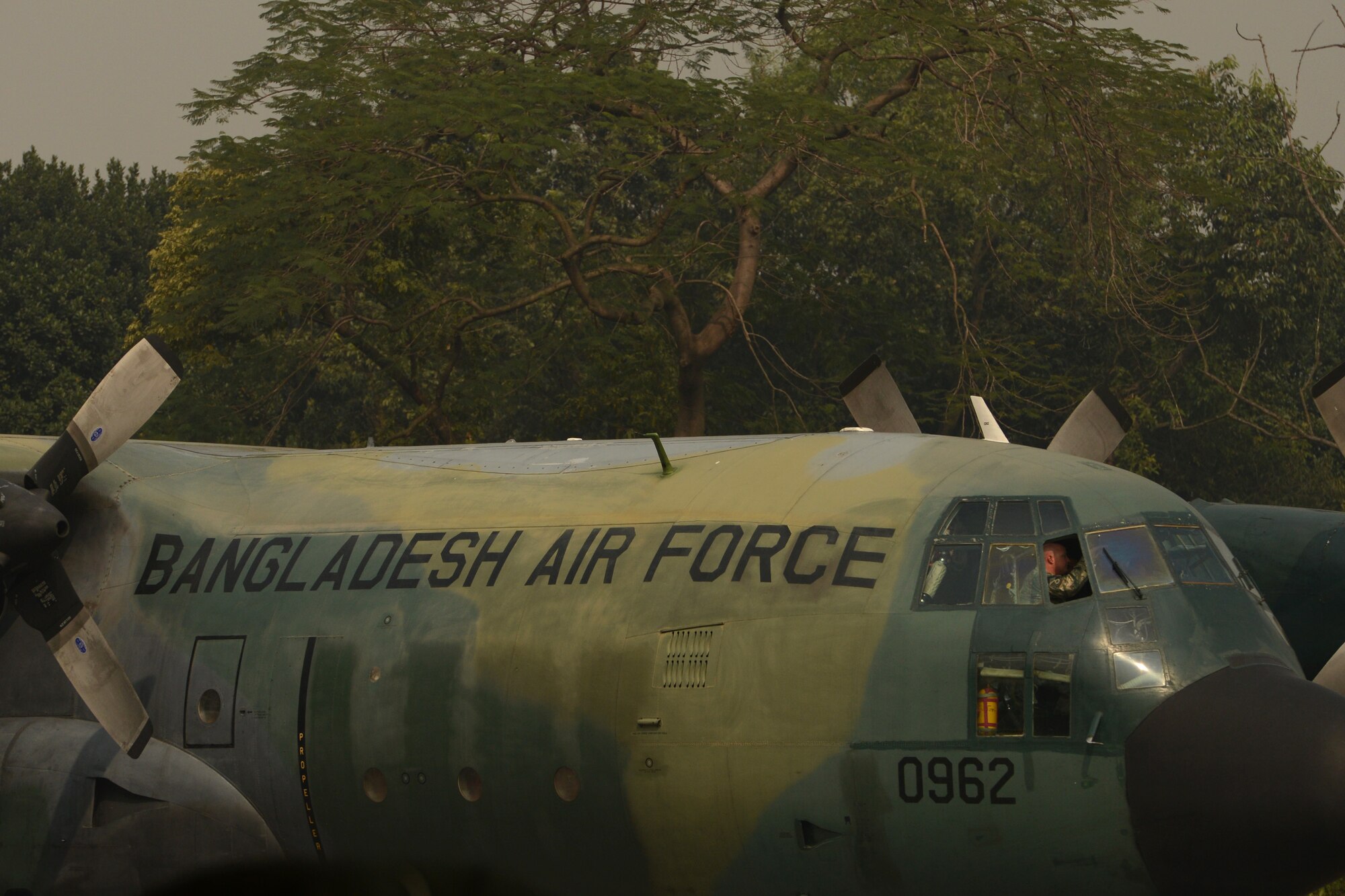 U.S. Air Force Senior Master Sgt. Ben Miller sits on the flight deck of a Bangladesh Air Force C-130B from the 101st Special Flying Unit during a subject matter expert exchange at Exercise COPE SOUTH, BAF Base Bangabandhu, Jan. 27, 2015. Miller is assigned to the 374th Aircraft Maintenance Squadron, Yokota Air Base, Japan. COPE SOUTH is a Pacific Air Forces-sponsored, bilateral tactical airlift exercise conducted in Bangladesh, with a focus on cooperative flight operations, day and night low-level navigation, tactical airdrop, and air-land missions as well as subject-matter expert exchanges in the fields of operations, maintenance and rigging disciplines. (U.S. Air Force photo by 1st Lt. Jake Bailey/Released)