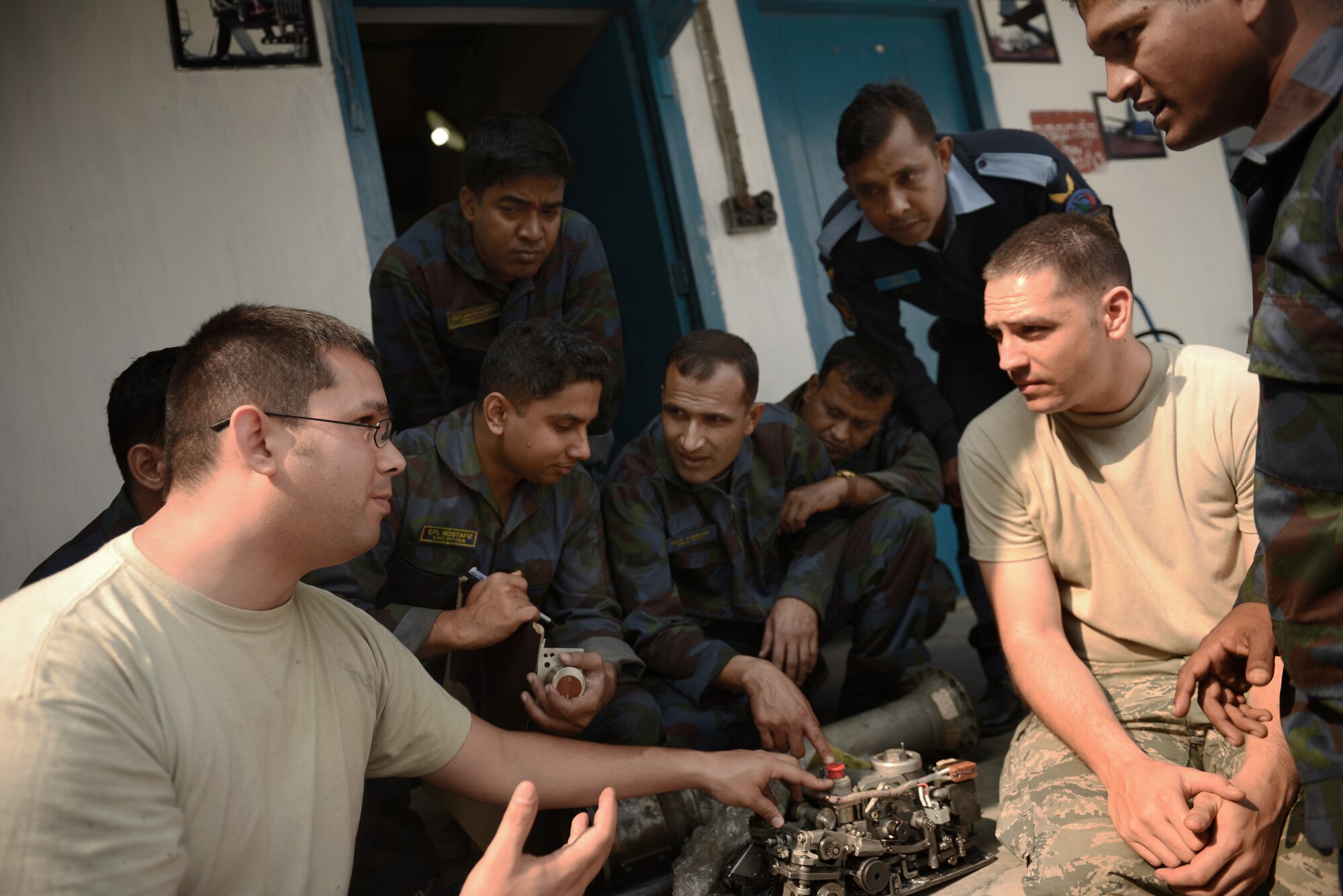 U.S. Air Force Tech. Sgt. Sam Bishop (left) and Staff Sgt. Jeffrey meet with Bangladesh Air Force maintenance counterparts from the 101st Special Flying Unit to discuss propeller valve functions during Exercise COPE NORTH at BAF Base Bangabandhu, Jan. 27, 2015. Bishop and Stephens are aerospace propulsion specialists assigned to the 374th Maintenance Group, Yokota Air Base, Japan. COPE SOUTH helps cultivate common bonds, foster goodwill, and improve readiness and compatibility between members of the Bangladesh and U.S. Air Forces. (U.S. Air Force photo by 1st Lt. Jake Bailey/Released)