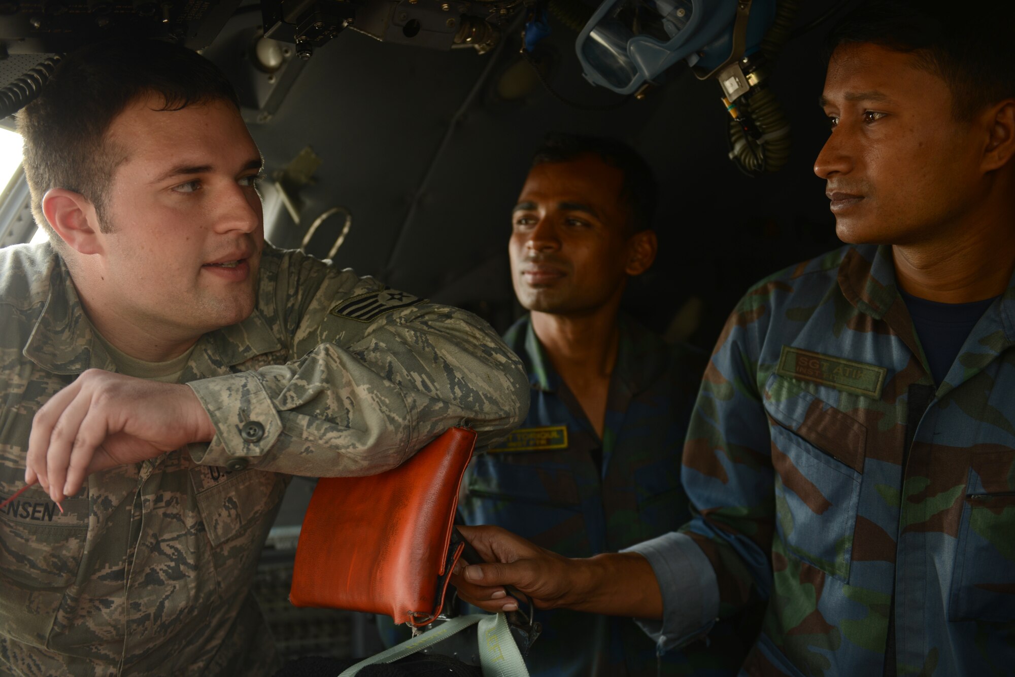 U.S. Air Force Staff Sgt. Scott Sorensen (left) discusses C-130 aircraft control systems maintenance considerations with Bangladesh Air Force Sergeants Atik and Toriqul during Exercise COPE NORTH at BAF Base Bangabandhu, Jan. 27, 2015. Sorensen is a C-130H guidance and control specialist assigned to the 374th Aircraft Maintenance Squadron, Yokota Air Base, Japan. COPE SOUTH is a Pacific Air Forces-sponsored, bilateral tactical airlift exercise conducted in Bangladesh, with a focus on cooperative flight operations, day and night low-level navigation, tactical airdrop, and air-land missions as well as subject-matter expert exchanges in the fields of operations, maintenance and rigging disciplines. (U.S. Air Force photo by 1st Lt. Jake Bailey/Released)