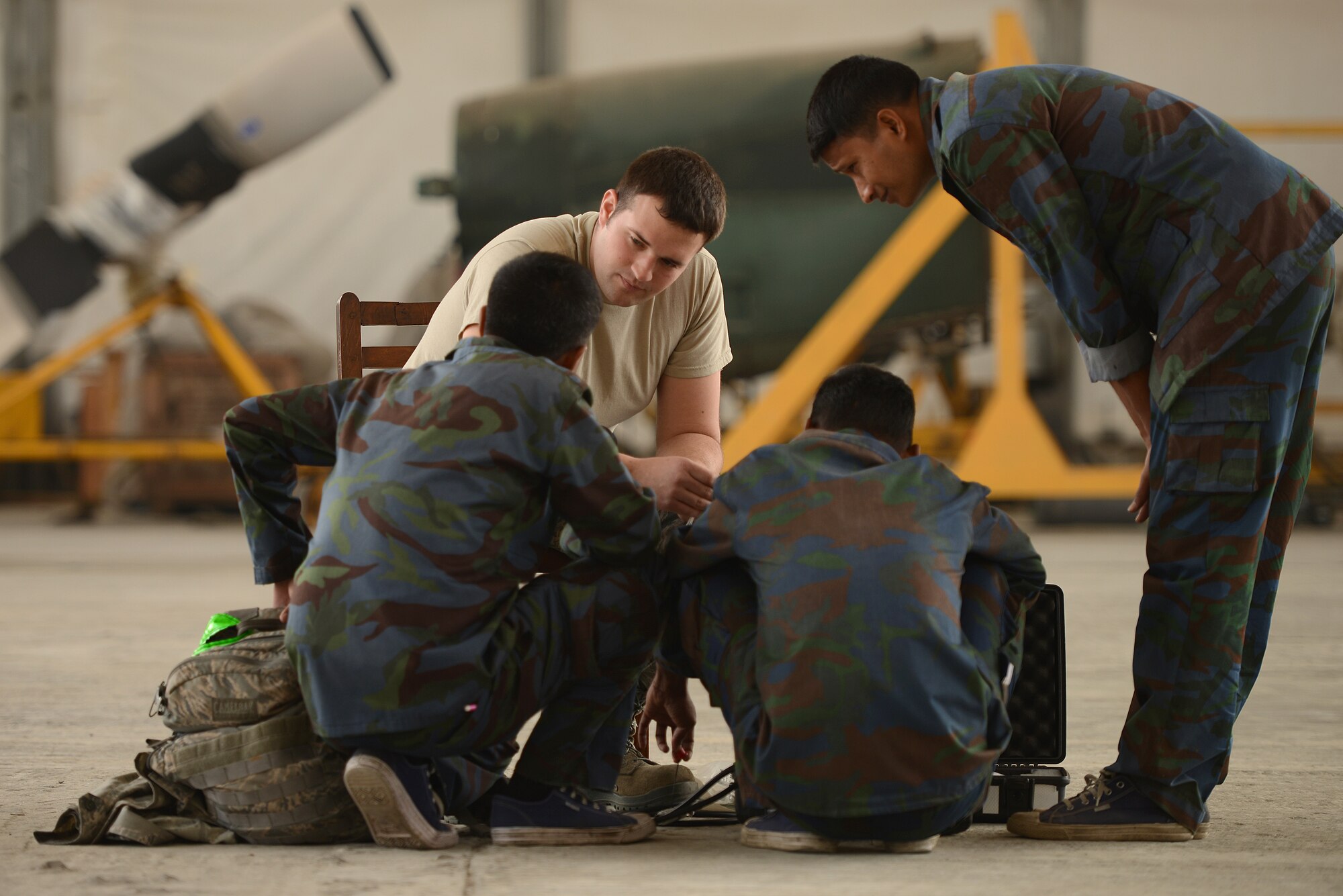 U.S. Air Force Staff Sgt. Scott Sorensen discusses C-130 aircraft control system maintenance considerations with Bangladesh Air Force maintenance personnel from the 101st Special Flying Unit during Exercise COPE NORTH at BAF Base Bangabandhu, Jan. 27, 2015. Sorensen is a C-130H guidance and control specialist assigned to the 374th Aircraft Maintenance Squadron, Yokota Air Base, Japan. COPE SOUTH is a Pacific Air Forces-sponsored, bilateral tactical airlift exercise conducted in Bangladesh, with a focus on cooperative flight operations, day and night low-level navigation, tactical airdrop, and air-land missions as well as subject-matter expert exchanges in the fields of operations, maintenance and rigging disciplines. (U.S. Air Force photo by 1st Lt. Jake Bailey/Released)