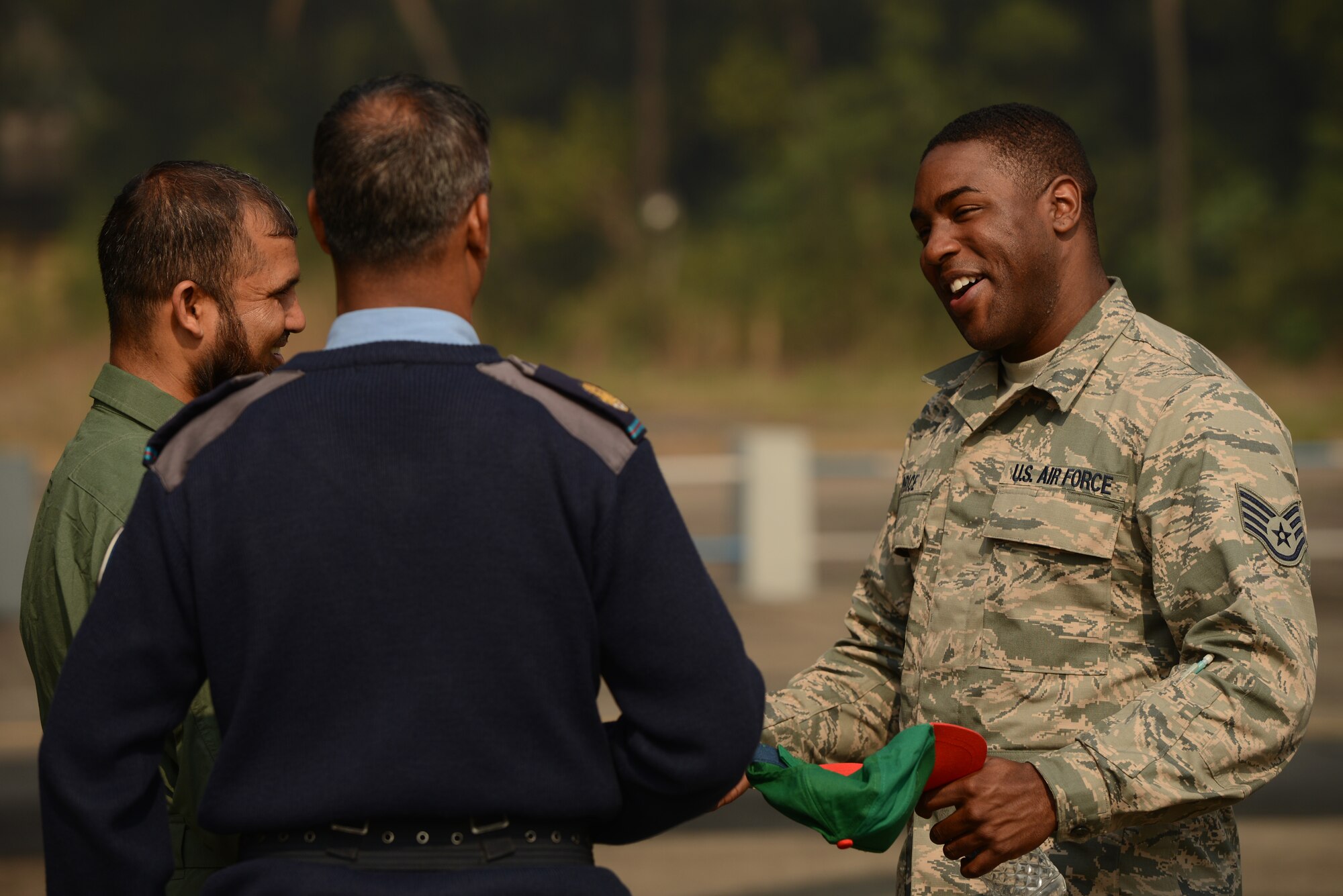 U.S. Air Force Staff Sgt. Justin Price speaks with Bangladesh Air Force maintenance counterparts during Exercise COPE SOUTH at BAF Base Bangabandhu, Jan. 27, 2015. Price is a repair and reclamation specialist assigned to the 374th Maintenance Squadron, Yokota Air Base, Japan. COPE SOUTH helps cultivate common bonds, foster goodwill, and improve readiness and compatibility between members of the Bangladesh and U.S. Air Forces. (U.S. Air Force photo by 1st Lt. Jake Bailey/Released)
