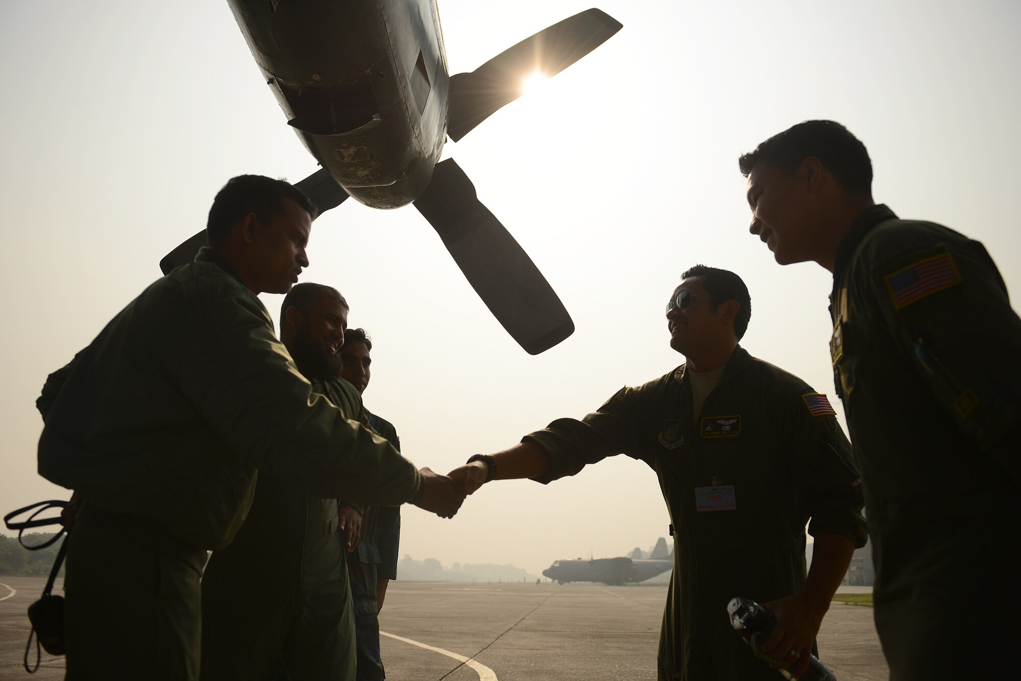 U.S. Air Force C-130H crew members from the 36th Airlift Squadron, Yokota Air Base, Japan, meet with a Bangladesh Air Force C-130B crew from the 101st Special Flying Unit during Exercise COPE SOUTH at BAF Base Bangabandhu, Jan. 27, 2015. COPE SOUTH is a Pacific Air Forces-sponsored, bilateral tactical airlift exercise conducted in Bangladesh, with a focus on cooperative flight operations, day and night low-level navigation, tactical airdrop, and air-land missions as well as subject-matter expert exchanges in the fields of operations, maintenance and rigging disciplines. COPE SOUTH helps cultivate common bonds, foster goodwill, and improve readiness and compatibility between members of the Bangladesh and U.S. Air Forces. (U.S. Air Force photo by 1st Lt. Jake Bailey/Released)