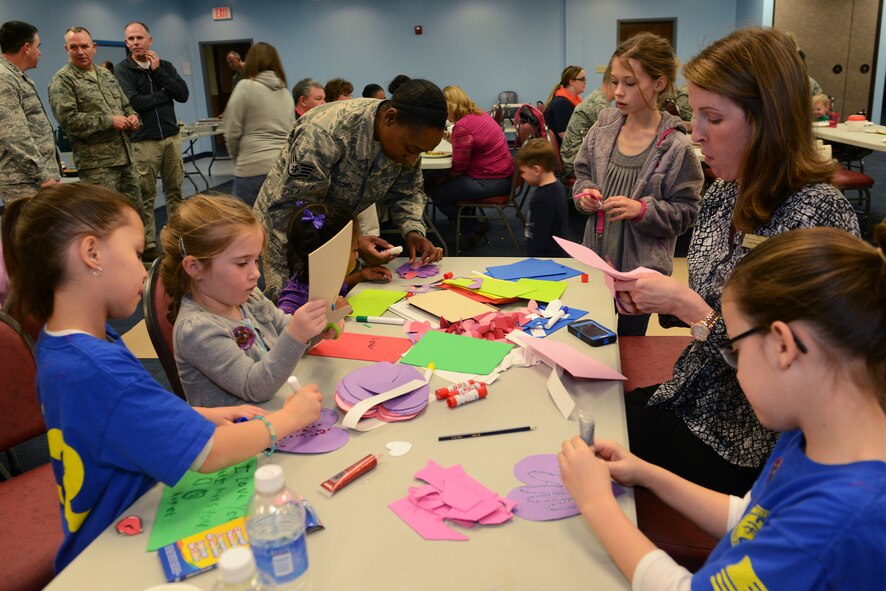 Children of deployed service members make cards for their deployed parent in the chapel Jan. 29, 2015, at Moody Air Force Base, Ga. A photo booth was set up for the children to take pictures to send to their deployed family member during the Deployed and Remote Family Dinner. (U.S. Air Force photo by Airman 1st Class Kathleen D. Bryant/Released)