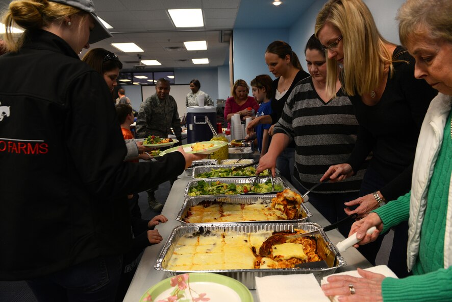 Volunteers serve families of deployed service members during the Deployed and Remote Family Dinner Jan. 29, 2015, at Moody Air Force Base, Ga. A local church sponsored the food at the event held in the base chapel. (U.S. Air Force photo by Airman 1st Class Kathleen D. Bryant/Released)