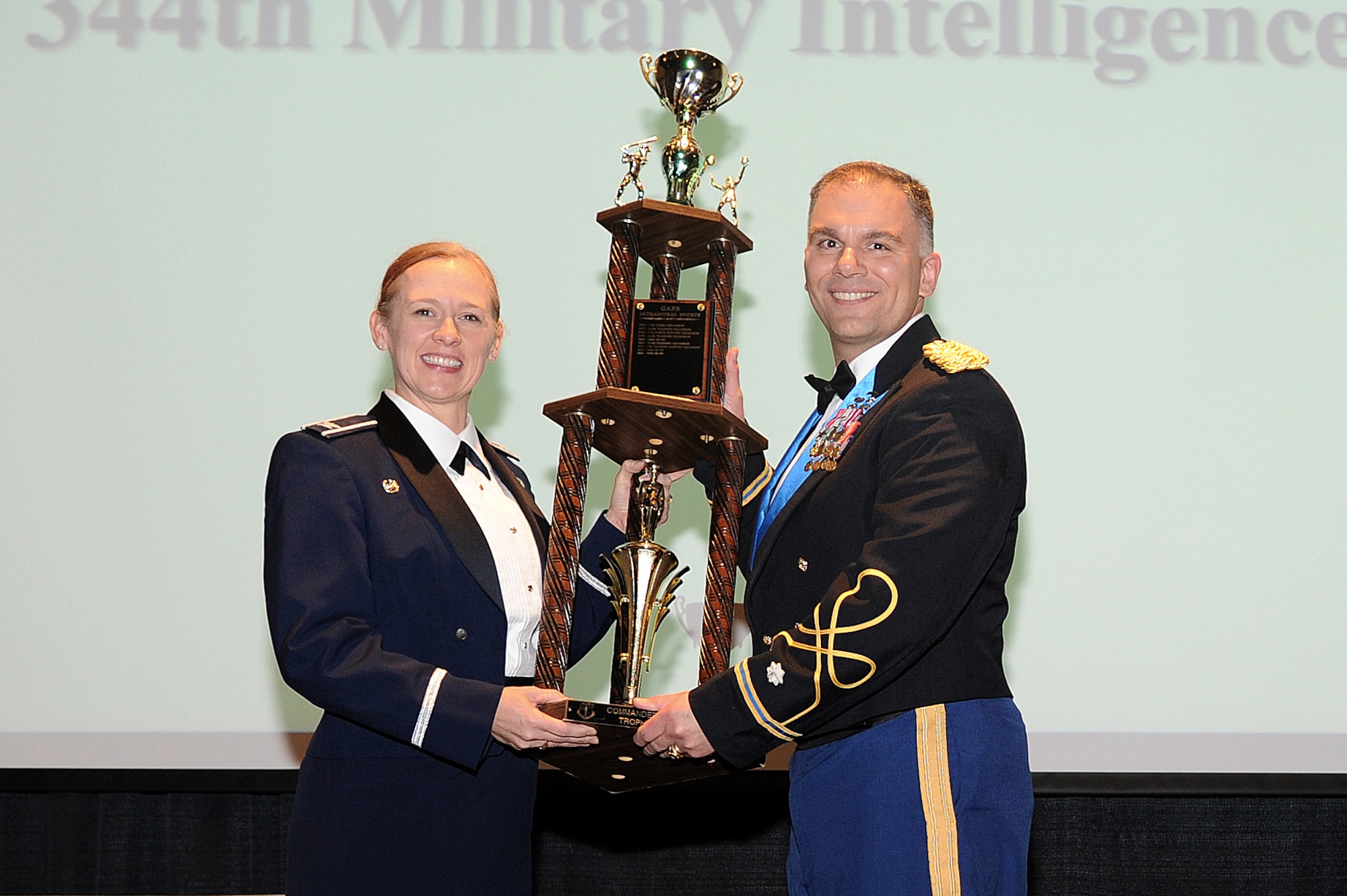SAN ANGELO, Texas – Col. Kimberlee P. Joos, 17th Training Wing Commander, presents Lt. Col. Jason D. Hallock, 344th Military Intelligence Battalion Commander, the Goodfellow Air Force Base intramural sports program Commander’s Trophy during the Annual Awards Banquet at the McNease Convention Center Jan. 30. (U.S. Air Force photo/ Airman 1st Class Devin Boyer)