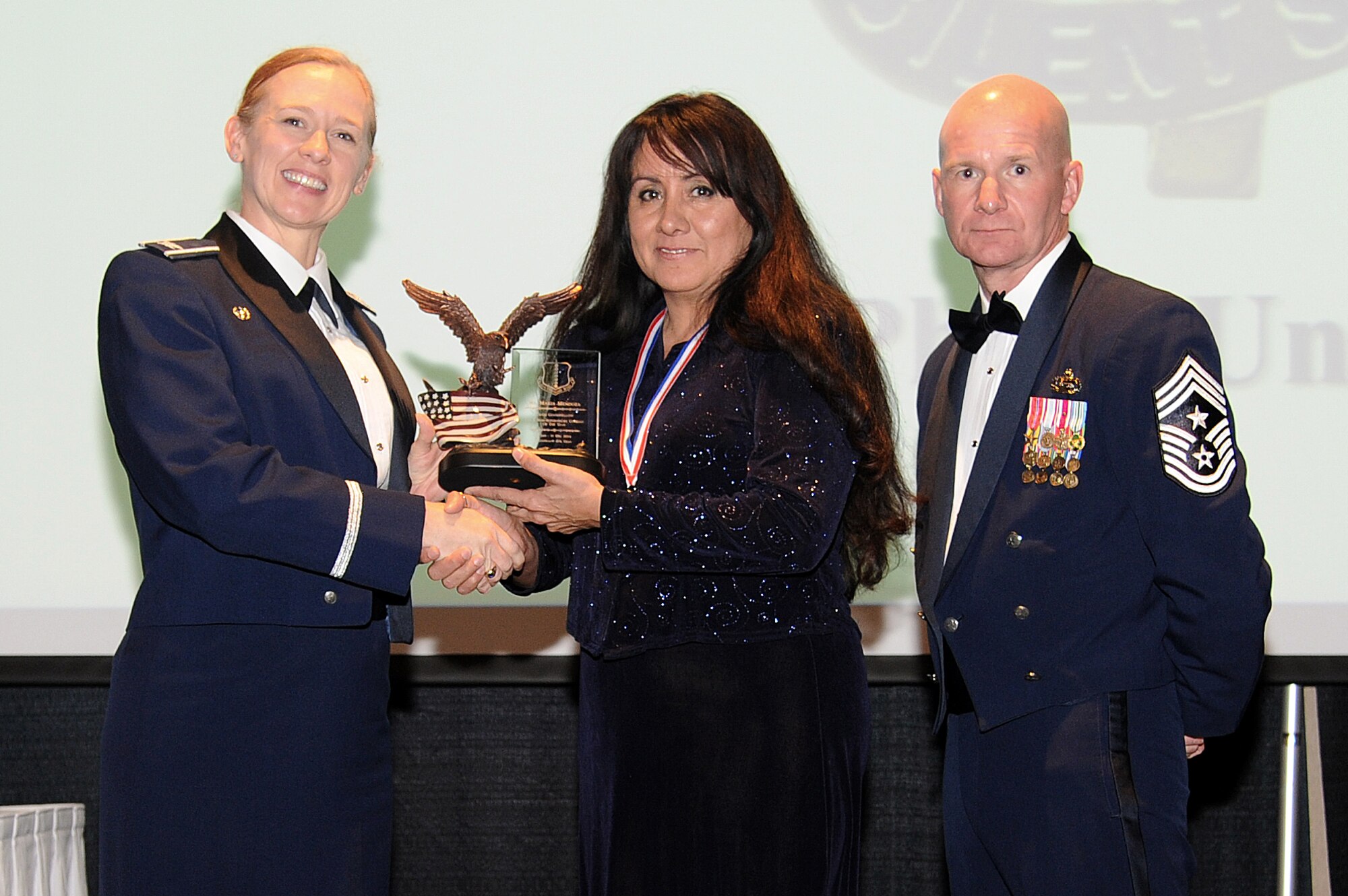 SAN ANGELO, Texas – Col. Kimberlee P. Joos, 17th Training Wing Commander, and Chief Master Sgt. Thomas F. Good, 17th TRW Command Chief, present Maria Mendoza, 344th Military Intelligence Battalion, the Team Goodfellow 2014 Civilian Category I (Non-supervisory) of the Year award during the Annual Awards Banquet at the McNease Convention Center Jan. 30. (U.S. Air Force photo/ Airman 1st Class Devin Boyer)
