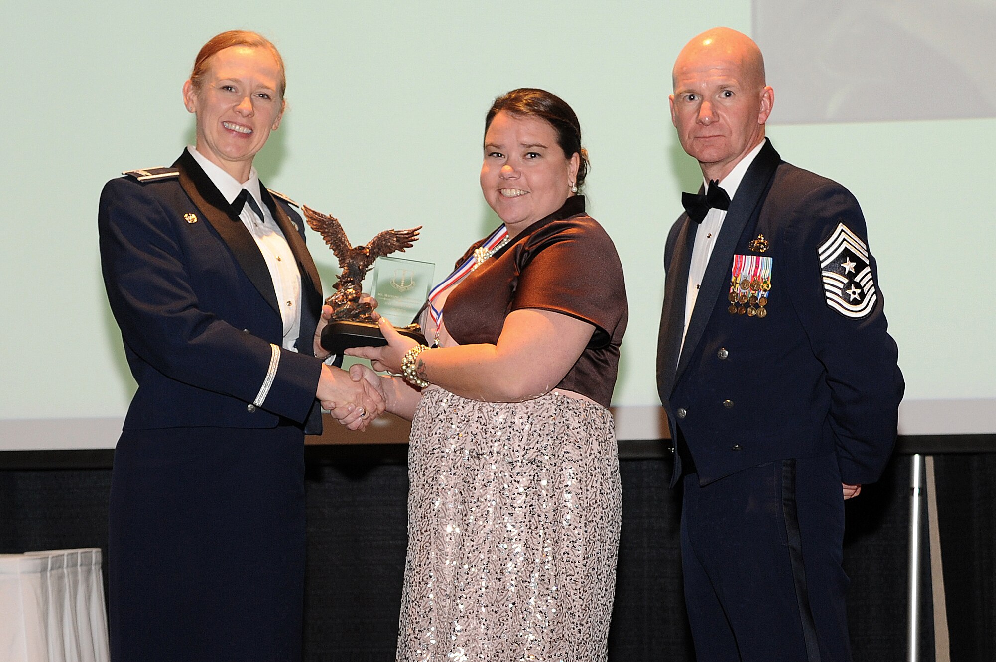 SAN ANGELO, Texas – Col. Kimberlee P. Joos, 17th Training Wing Commander, and Chief Master Sgt. Thomas F. Good, 17th TRW Command Chief, present Madeline E. Henderson the 17th Training Wing and Team Goodfellow 2014 Key Spouse of the Year award during the Annual Awards Banquet at the McNease Convention Center Jan. 30. (U.S. Air Force photo/ Airman 1st Class Devin Boyer)
