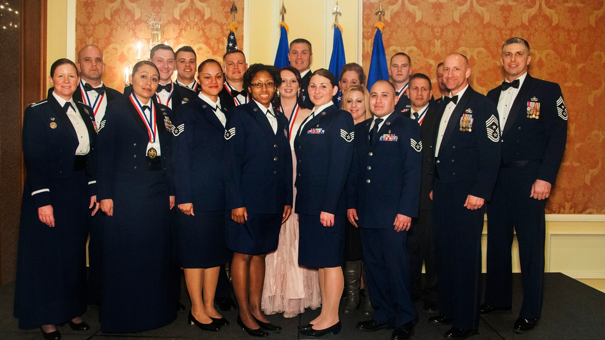 Col. Tracey Hayes, 90th Misille Wing commander; Chief Master Sgt. Samuel Couch, 90th MW command chief; and Chief Master Sgt. (Ret.) Eric Jaren, Vice President of Operations and Strategic Development at CompTech Compter Technologies Inc., pose for a photo with the 90th MW annual award winners Jan. 30, 2015. Mighty Ninety Airmen recieved awards in 13 categories, with many winners moving on to compete at the Air Force level. (U.S. Air Force photo by Lan Kim)