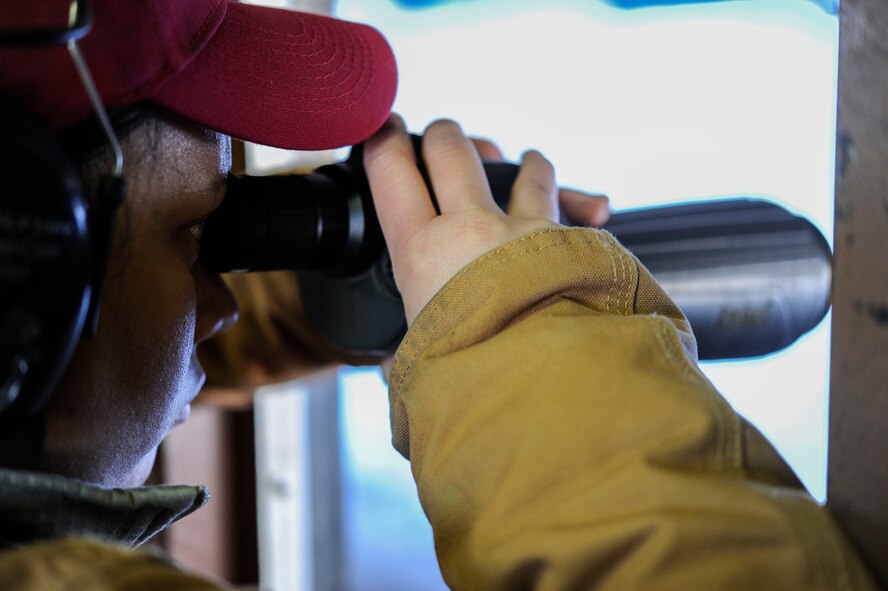 Staff Sgt. Joanna Richmond, 5th Security Forces Squadron combat arms training and maintenance instructor, uses a monocular to help a student sight in their rifle during M4 rifle training on Minot Air Force Base, N.D., Jan. 12, 2015. Richmond instructed the group on fundamentals in the classroom and oversaw the range for the practical portion of training. (U.S. Air Force photo/Senior Airman Stephanie Morris)