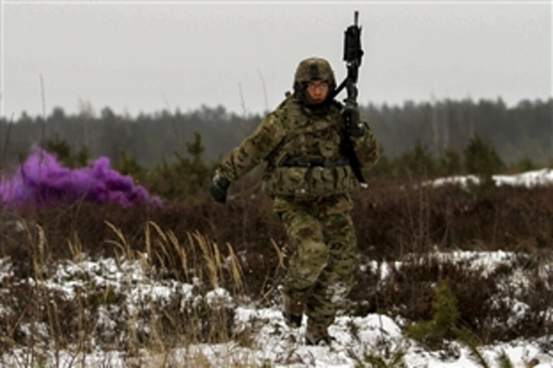 A U.S. soldier runs to his next objective under the cover of purple smoke during a squad training exercise in Adazi, Latvia, Jan. 28, 2015. The training event is part of the squad's participation in Operation Atlantic Resolve.
