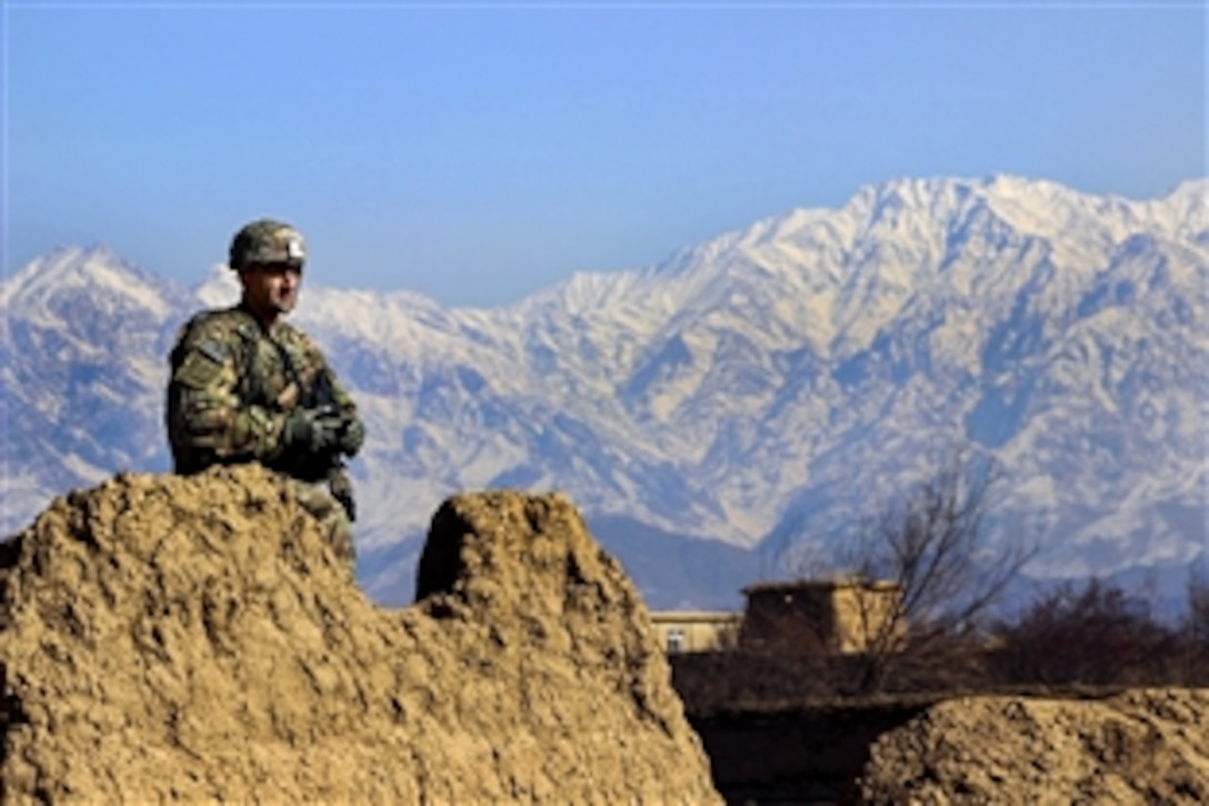 U.S. Army Sgt. 1st Class Hickman provides security from behind a partial stone wall during a patrol with Czech and Afghan soldiers through a village in Parwan province, Afghanistan, Jan. 27, 2015. Hickman is assigned to the 2nd Squadron, 3rd Cavalry Regiment.