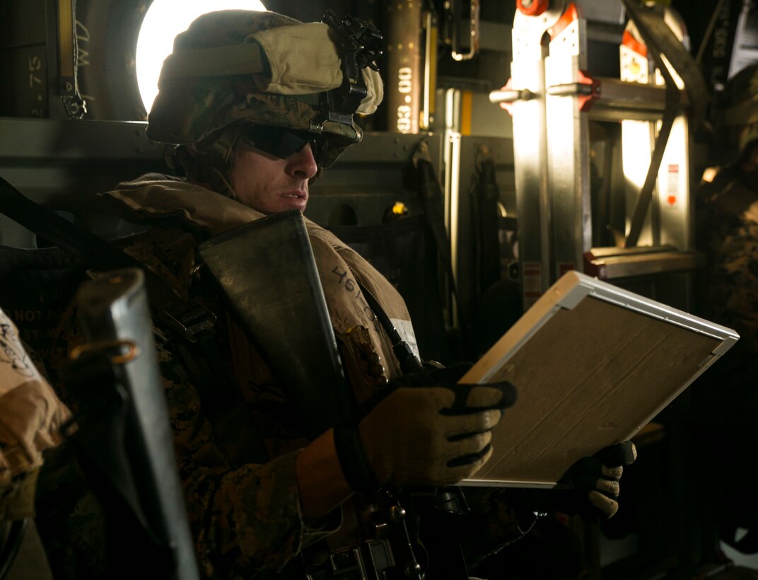 A Marine with Special-Purpose Marine Air-Ground Task Force Crisis Response – Africa, reads a dry-erase board with mission-essential notes while flying in an MV-22 Osprey during an alert-force drill launched from Morón Air Base, Spain, Jan. 29, 2015. The Marines used hand and arm signals along with the board to communicate over the noise of the aircraft as they prepared to land for their simulated casualty evacuation mission. (U.S. Marine Corps photo by Sgt. Paul Peterson/Released)