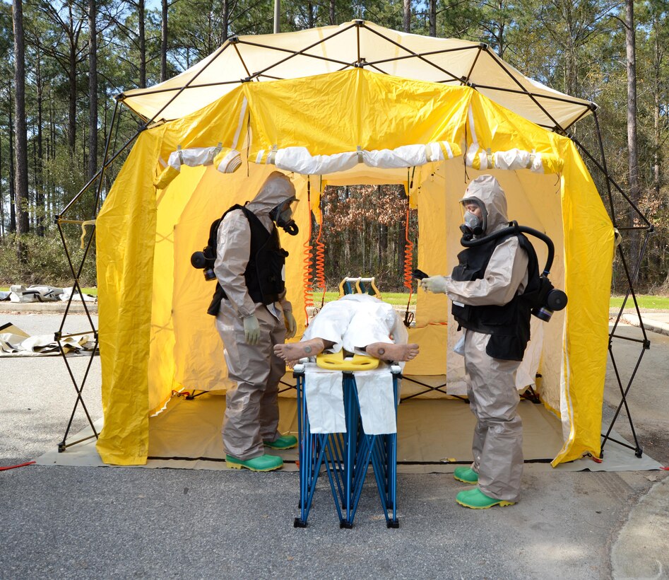 Navy personnel practice treating a victim while wearing protective clothing during training recently at the Naval Branch Health Clinic Albany aboard Marine Corps Logistics Base Albany.