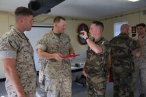 Captain Daniel F. Burns, a ground intelligence officer for 2nd Bn., 6th Marines, Capt. Kelby Breivogel, an information officer with 2nd Bn., 6th Marines, and Capt. Stephen Castillo, a French officer embedding with 2nd Battalion, 6th Marine Regiment, 2nd Marine Division, talk over future plans for the unit’s international exercise, Bold Alligator, during an award ceremony aboard Marine Corps Base Camp Lejeune, Oct. 20, 2014. “We will accept them into the battalion, they’ll partner with us, they’ll go on missions with us, and they’ll observe our staff planning. We’re really going to work hard to integrate them into all of our planning exercises,” said Lt. Col. James Lively, the commanding officer for 2nd Bn., 6th Marines.