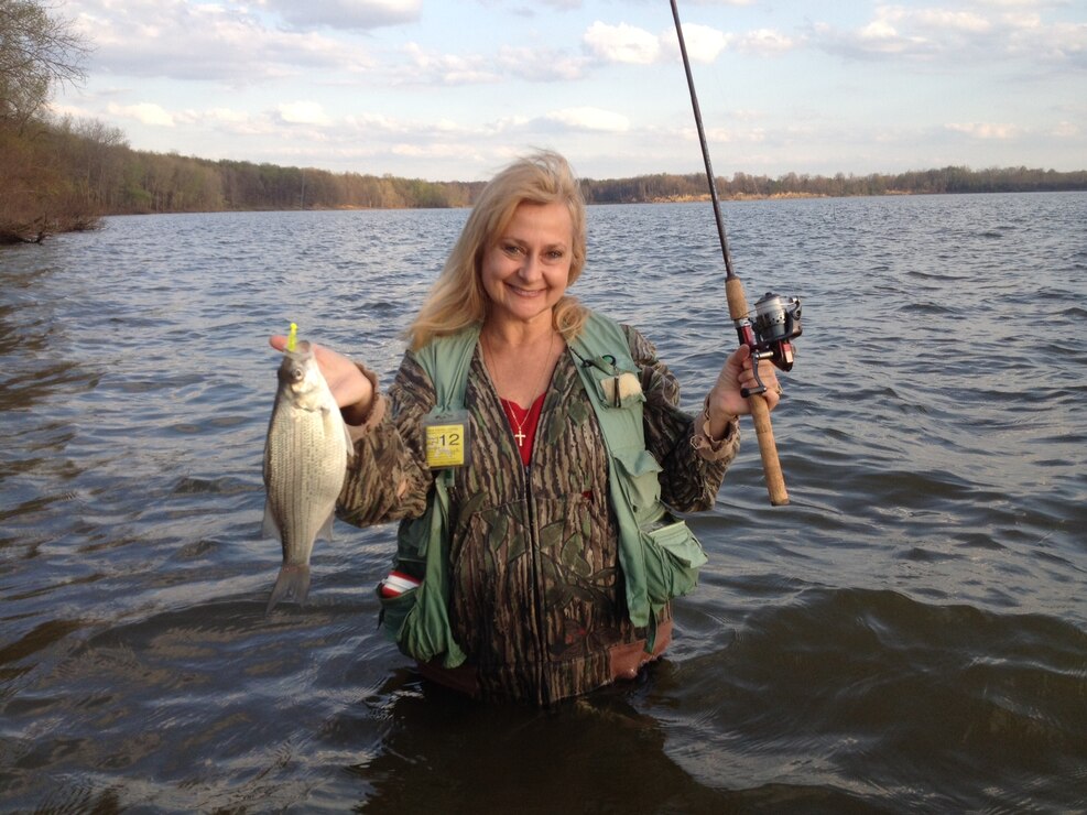 A happy angler, Dianne Kolodziejski a resource manager at Mosquito Creek Lake, displays the catch of the day at Shenango Lake. 