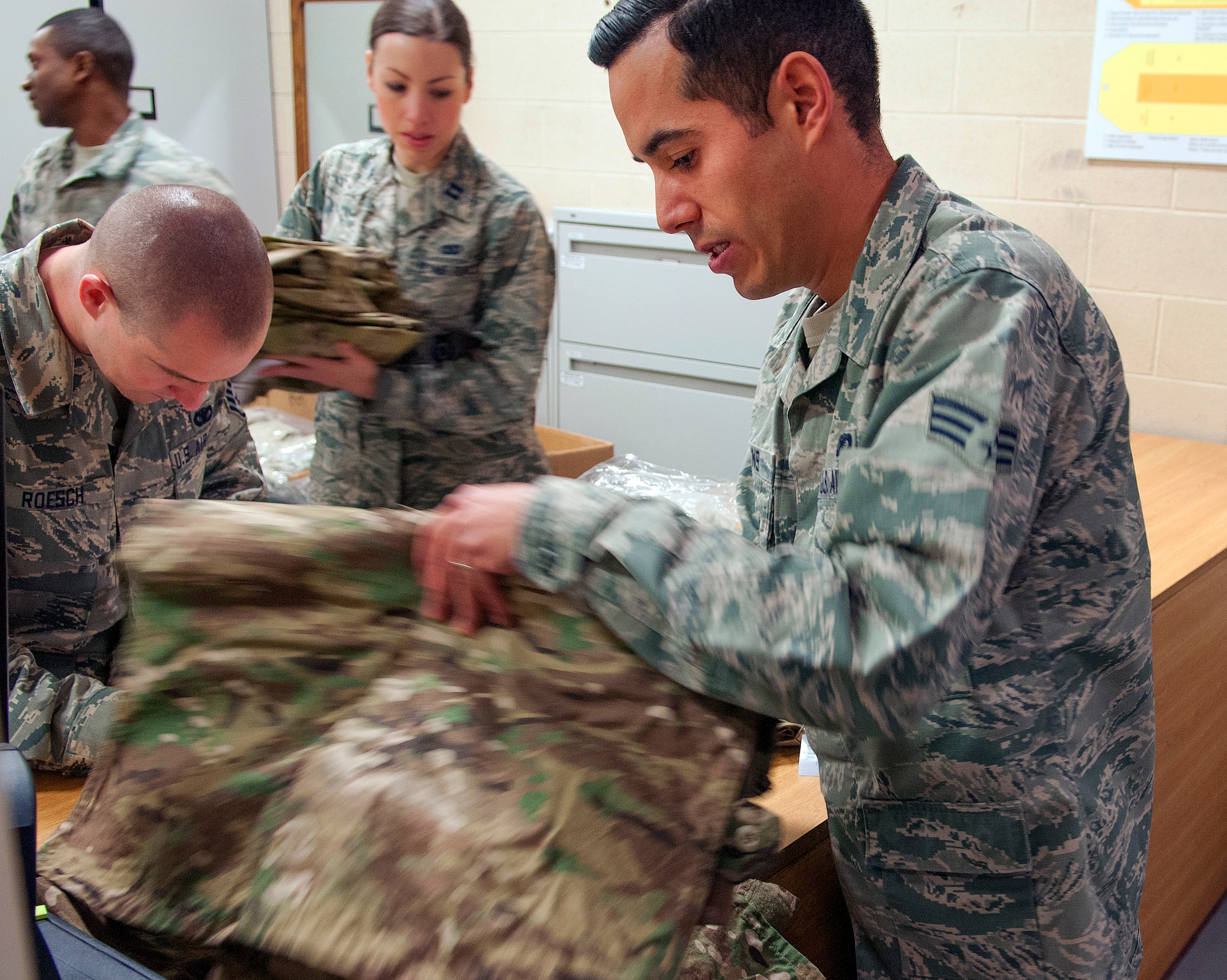 Senior Airman Tyler Collins, 790th Missile Security Forces Squadron Security Support Team, looks through his new Operation Enduring Freedom Camouflage Pattern uniforms Feb. 2, 2015, in the Peacekeeper High Bay on F.E. Warren Air Force Base, Wyo. Defenders who travel out to the missile field received new gear and uniforms as part of the 20th Air Force Model Defender Program. (U.S. Air Force photo by Airman 1st Class Brandon Valle)