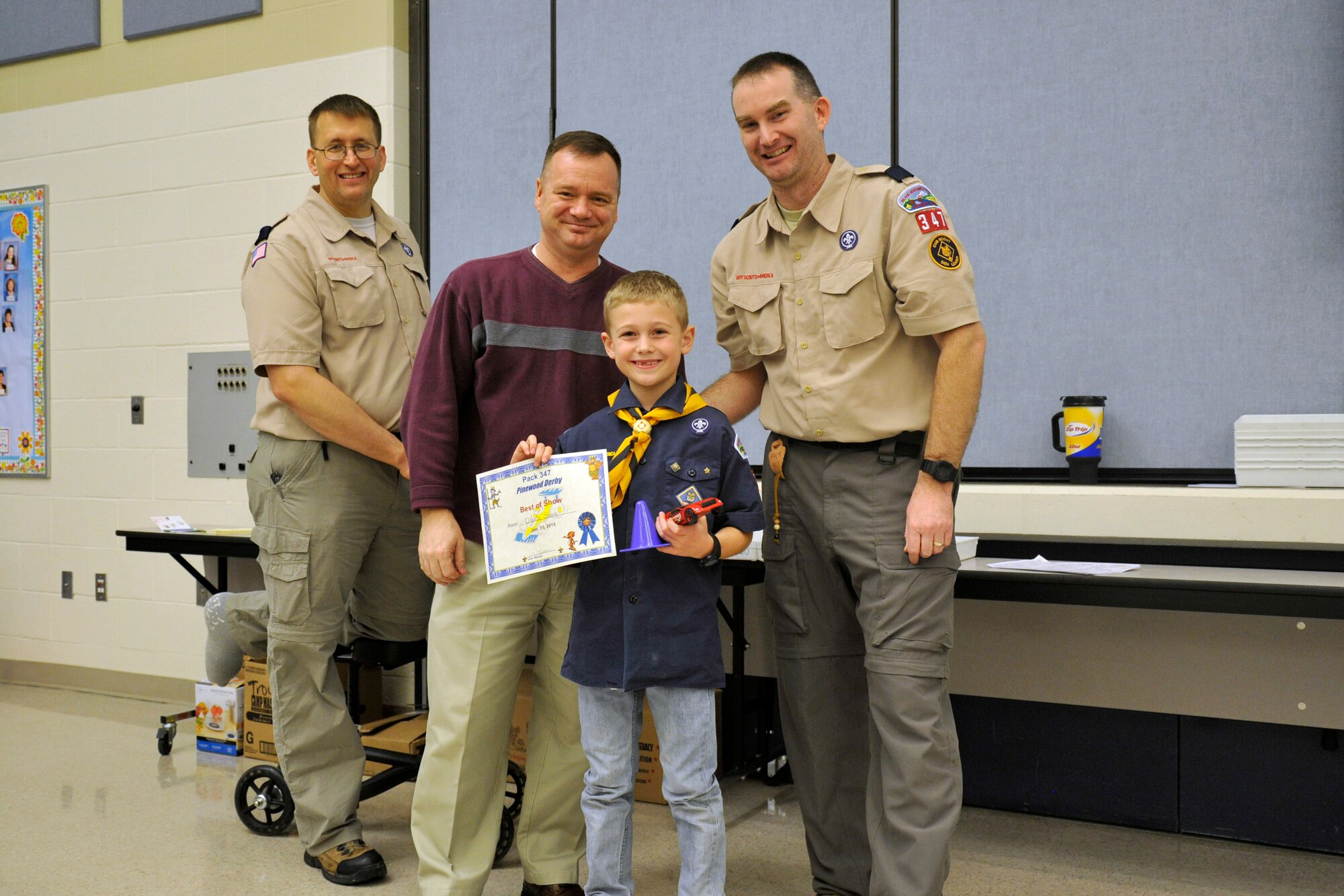 Senior Master Sgt. Lester Gaither (left), 92nd Maintenance Group superintendent and cub master for Pack 347, Col. Brian McDaniel (center), 92nd Air Refueling Wing commander, Maj. Brad Hickey (right), 92nd Force Support Squadron force support operations officer and pose with Wolf Scout Dakota Stone, the winner of the “Best of Show” contest. McDaniel and Chief Master Sgt. Christian M. Pugh, 92nd ARW command chief, were guest judges for the ‘Best of Show’ contest. (U.S. Air Force photo/Airman 1st Class Nicolo J. Daniello)  