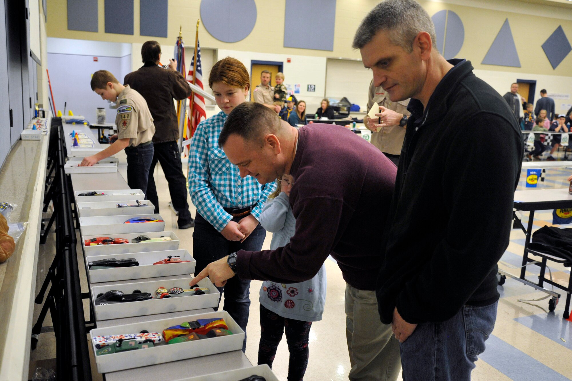 Col. Brian McDaniel, 92nd Air Refueling Wing commander and Chief Master Sgt. Christian Pugh, 92nd ARW command chief, examine multiple cars entered into the Pinewood Derby Jan. 31, 2015, at Fairchild Air Force Base, Wash. McDaniel and Pugh were guest judges for the “best of show” category at the event. (U.S. Air Force photo/Airman 1st Class Nicolo J. Daniello)