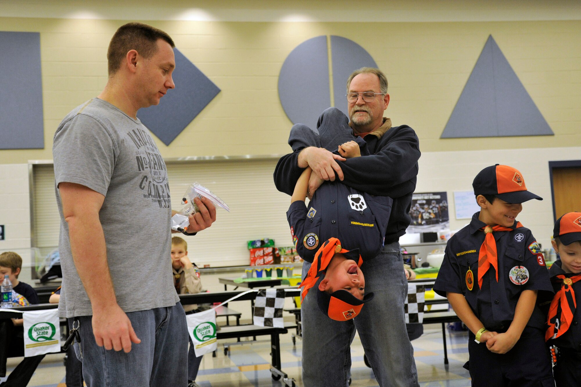 Tech. Sgt. Chris Runge, 92nd Maintenance Group development element NCO in charge, acting Pack 347 den leader, presents a Tiger Scout his bobcat patch Jan. 31, 2015, at Fairchild Air Force Base, Wash. The bobcat patch is placed on the Tiger Scout upside down and after he completes a “good turn,” or a good deed, he may turn his patch right side up symbolizing the first earned rank of a Cub Scout. (U.S. Air Force photo/Airman 1st Class Nicolo J. Daniello)