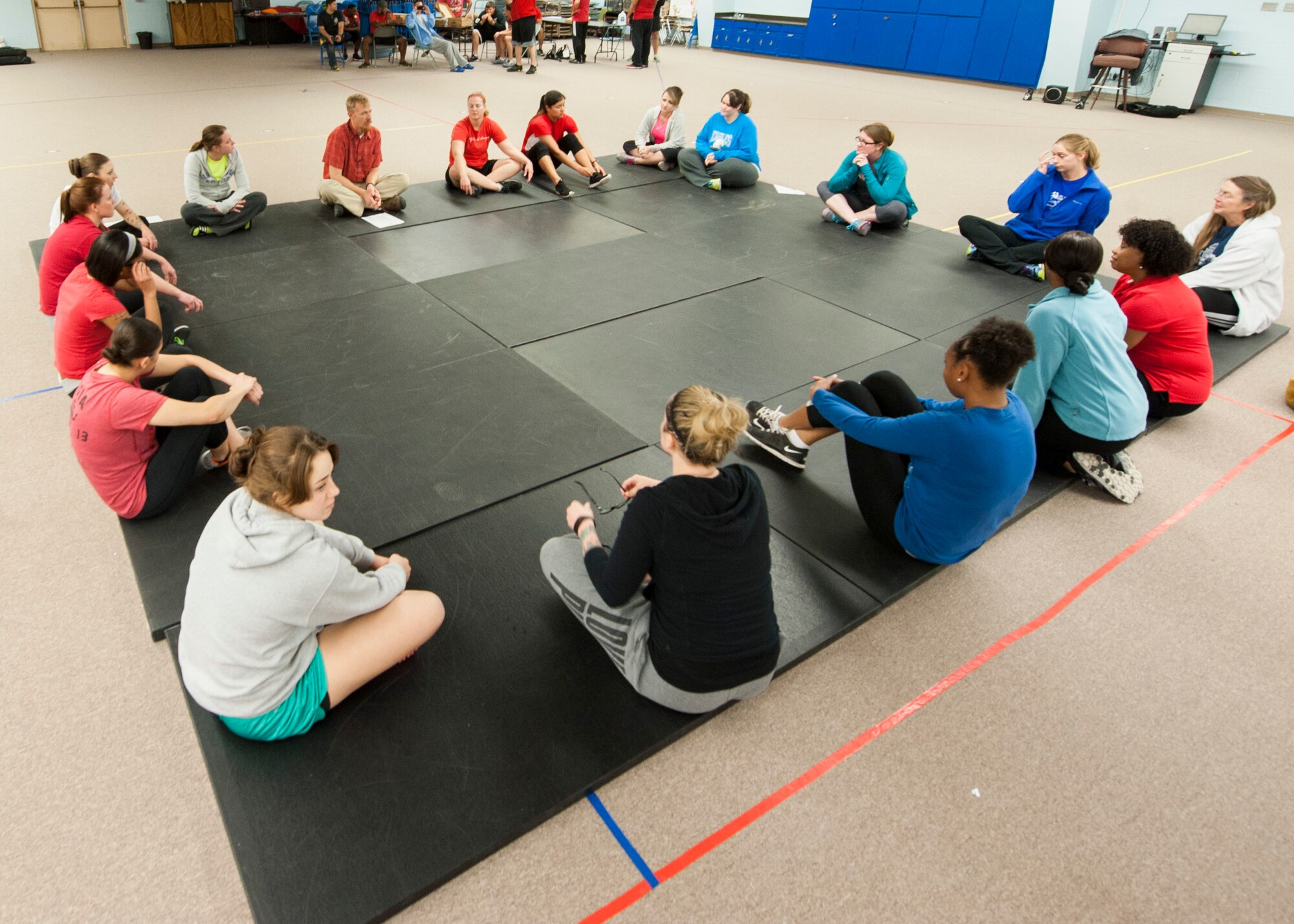 Fear Adrenaline Stress Training participants gather around to discuss self-defense tactics and how to manage emotions effectively during potentially dangerous situations Jan. 29, 2015, at Holloman Elementary School. During FAST, participants learn moves to help protect them in a situation in which they feel threatened or afraid. (U.S. Air Force photo by Airman 1st Class Emily A. Kenney/Released)