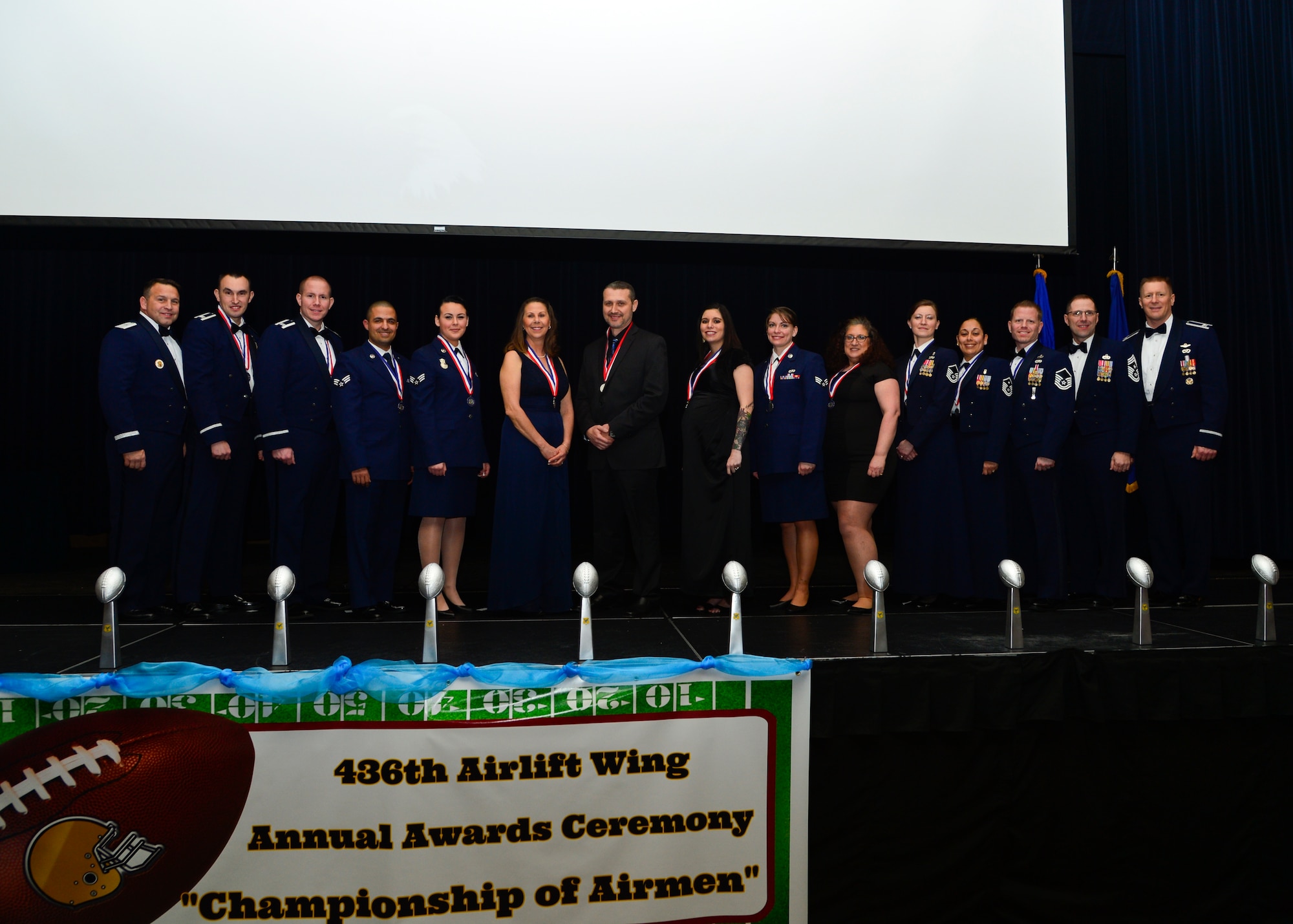 The 2014 annual award winners pose for a group photo with Brig. Gen. Thomas Sharpy, 18th Air Force vice commander, Col. Michael Grismer, 436th Airlift Wing commander and Chief Master Sgt. Stanley Cadell, 436th AW command chief, following the 2014 Annual Awards Ceremony Jan. 30, 2015, at the Rollins Center inside of Dover Downs, Dover, Del. This year’s ceremony theme was “Championship of Airmen”. (U.S. Air Force photo/Airman 1st Class William Johnson)