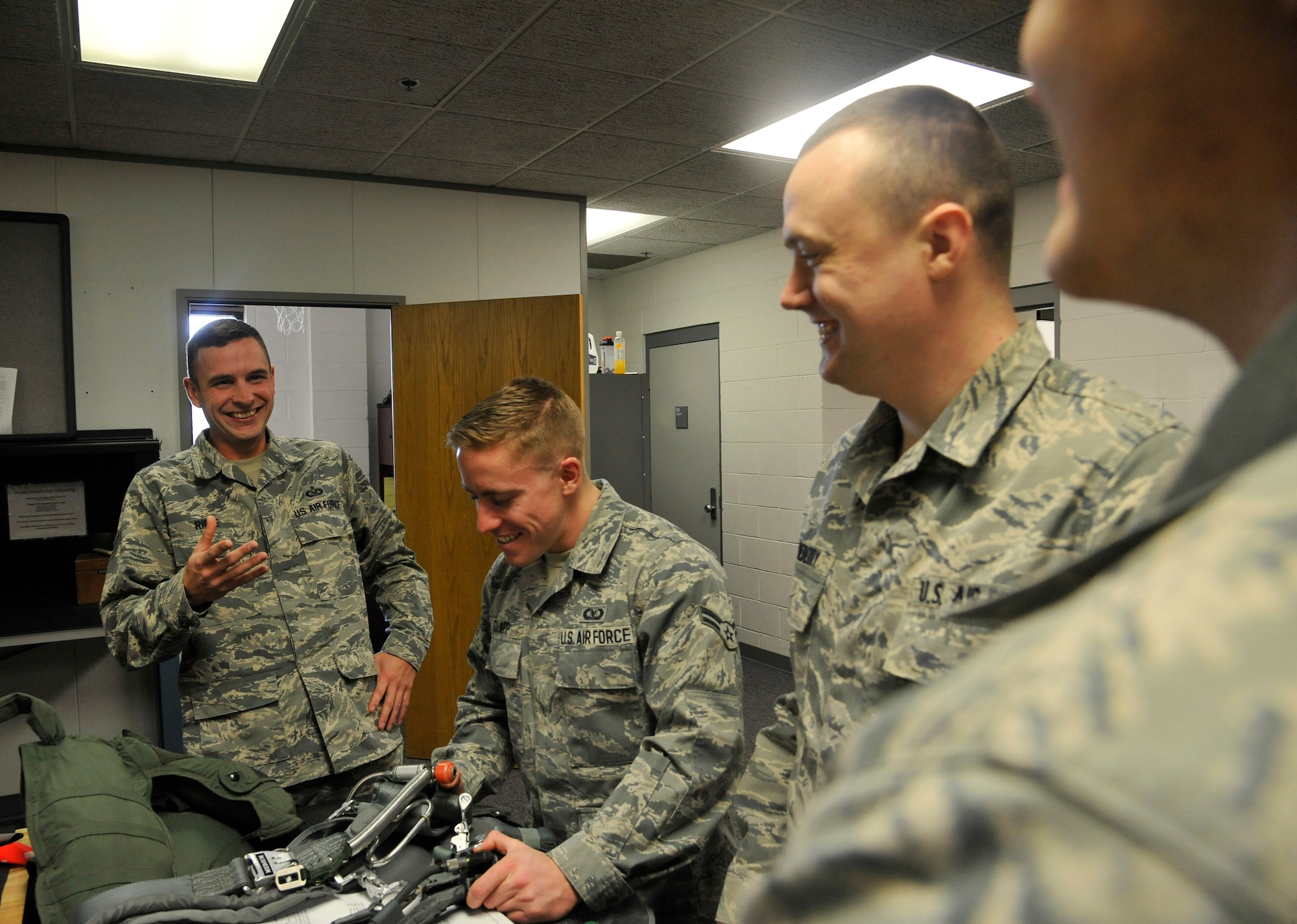 Staff Sgt. Joshua Riffe, 509th Operation Support Squadron aircrew flight equipment supervisor, jokes with his coworkers at Whiteman Air Force Base, Mo., Jan. 11, 2015. Morale coexists with the social and mental pillars of the comprehensive Airmen fitness. It enhances unit work performance and camaraderie, and fosters a well-balanced chemistry between coworkers. (U.S. Air Force photo by Senior Airman Keenan Berry/Released)