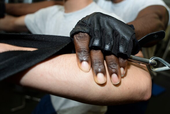U.S. Air Force Master Sgt. Mackenzie Mercer, Air Combat Command Communications Support Squadron noncommissioned officer-in-charge, adjusts the grip of Airman 1st Class Steven Hagewood, ACC CSS event manager, during a workout at Langley Air Force Base, Va., Jan. 30, 2015. Mercer believes assisting others with fitness opens up avenues of communication in a comfortable setting. (U.S. Air Force photo by Senior Airman Austin Harvill/Released)
