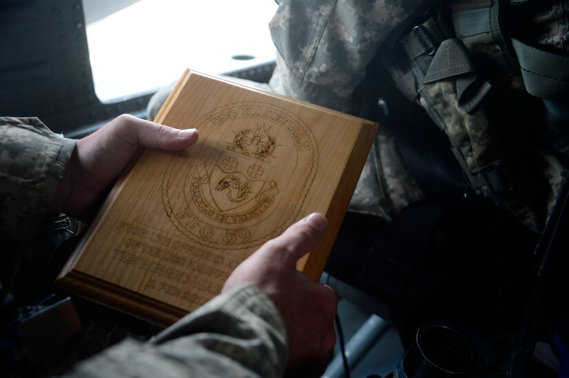 U.S. Army Sgt. 1st Class Kenneth Williams, crew chief assigned to the 1st Battalion, 228th Aviation Regiment, holds a plaque given to the 1-228th Avn. Reg. by the USS Kauffman after completing  the deck landing qualifications off the coast of Honduras, Feb. 1, 2015.  The 1-228th Avn. Reg. aircrew participated in deck landing qualifications on board the USS Kauffman to qualify pilots and crew chiefs on shipboard operations.   Kauffman is on its final scheduled deployment to the U.S. Southern Command area of responsibility supporting multinational, counter-narcotics operation known as Operation Martillo. (U.S. Air Force photo/Tech. Sgt. Heather Redman)
