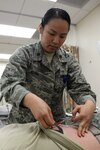 Maj. Becky Azama, 359th Medical Operations Squadron physical therapist, applies electrical stimulation to a patient Feb. 2, 2015, at the medical clinic on Joint Base San Antonio-Randolph, Texas. Electrical stimulation can be used as an alternative to medication for treating back pain. Walk-in appointments are now available from 7:15 to 8:45 a.m. on Mondays for active duty personnel at the JBSA-Randolph for musculoskeletal injuries occurring within seven days of their visit. (U.S. Air Force photo by Airman 1st Class Stormy Archer/Released)