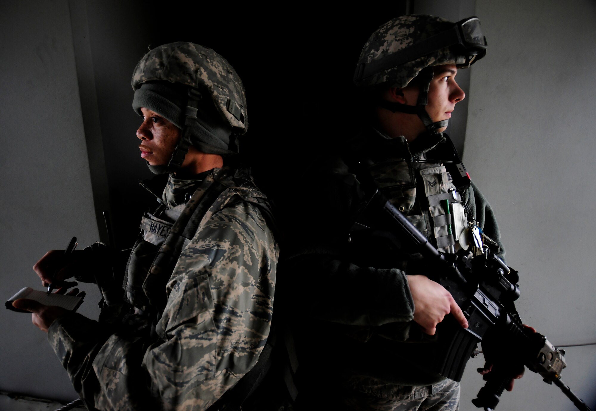 Senior Airmen DeMarcus Hayes (left), and Michael Dean, 39th Security Forces Squadron defenders, provide security while logging all emergency responders who enter the area during a base-wide exercise Jan. 28, 2015, at Incirlik Air Base, Turkey. The exercise tested the response time and capabilities of security forces members. (U.S. Air Force photo by Senior Airman Krystal Ardrey/Released)