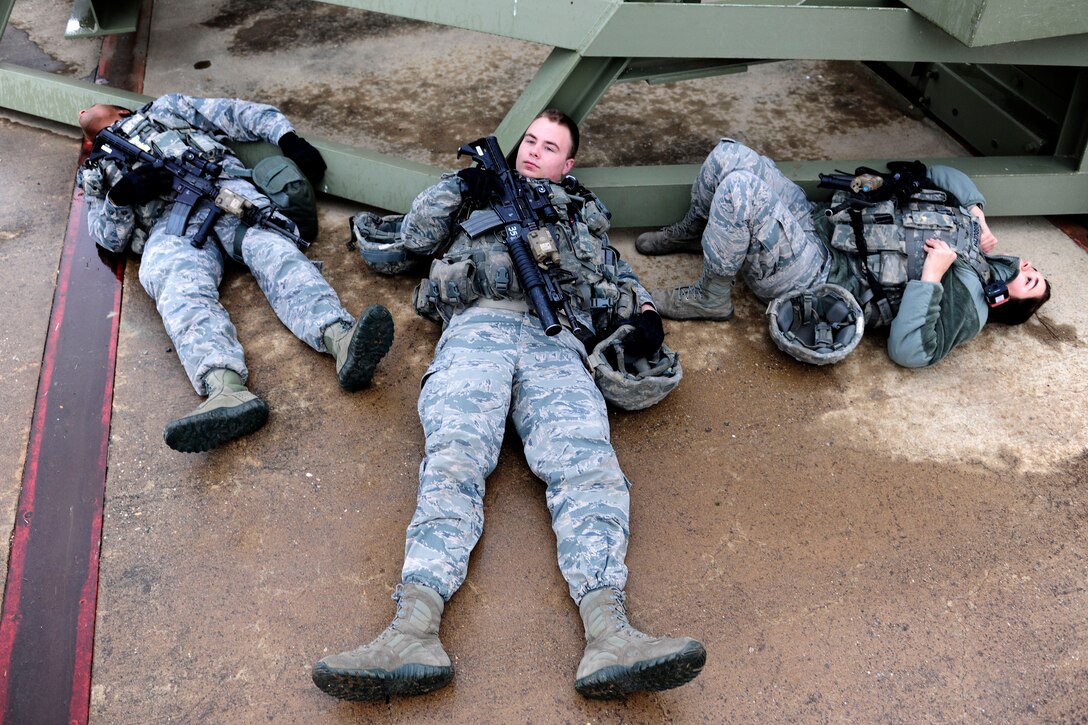 (From left) Staff Sgt. Mekcos Harris, 39th Security Forces Squadron area one supervisor, and Airmen 1st Class Joshua Peaden and Cheyenna Mosqueda, 39th SFS security response team members, lie on the ground to simulate casualties during a base-wide exercise Jan. 28, 2015, at Incirlik Air Base, Turkey. The exercise tested the response time of security forces and other first responders to an active shooter and mass causality event. (U.S. Air Force photo by Senior Airman Krystal Ardrey/Released)