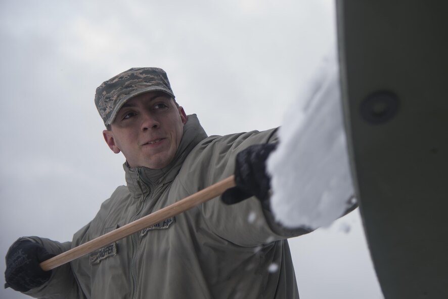 Senior Airman Erik Stauffer, 1st Combat Communications Squadron transmissions systems technician, cleans snow off of a satellite during exercise Juniper Thunder Jan. 30, 2015, at Ramstein Air Base, Germany. Juniper Thunder aimed to help the interoperability between Air Force and Army combat communications systems. (U.S. Air Force photo/Senior Airman Jonathan Stefanko)