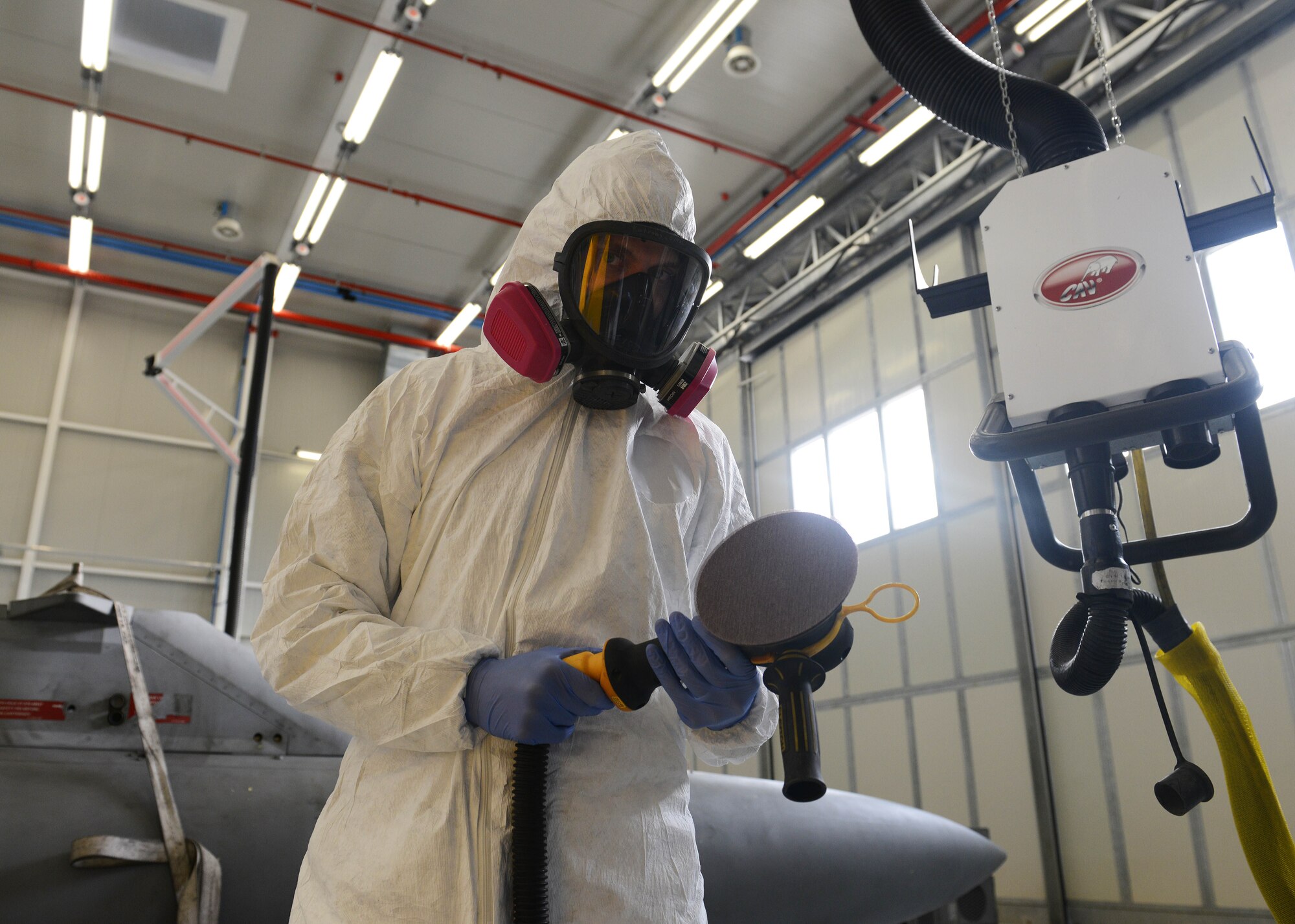 U.S. Air Force Senior Airman Cory Kotrous, 31st Maintenance Squadron aircraft structural maintenance journeyman, assembles an electric sander before sanding a F-16 Fighting Falcon fuel tank, Feb. 3, 2015, at Aviano Air Base, Italy. Sanding is considered one of the steps before painting an aircraft parts and improves paint and metal cohesion. Airmen clean the piece before applying primer and painting aircraft. (U.S. Air Force photo by Airman 1st Class Deana Heitzman/Released)