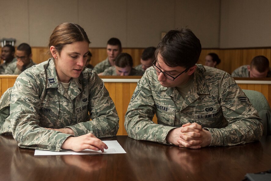 Capt. Erin Kenny, 8th Fighter Wing Area Defense Counsel attorney (left), advises the alleged perpetrator Senior Airman Nicholas Dastas, Armed Forces Network Kunsan broadcaster, during a sexual assault mock trial Jan. 27, 2015, at Kunsan Air Base, Republic of Korea. Wolf Pack Airmen from the First Term Airmen Center have the opportunity to witness a realistic portrayal of a sexual assault trial every month. (U.S. Air Force photo by Senior Airman Katrina Heikkinen/Released)