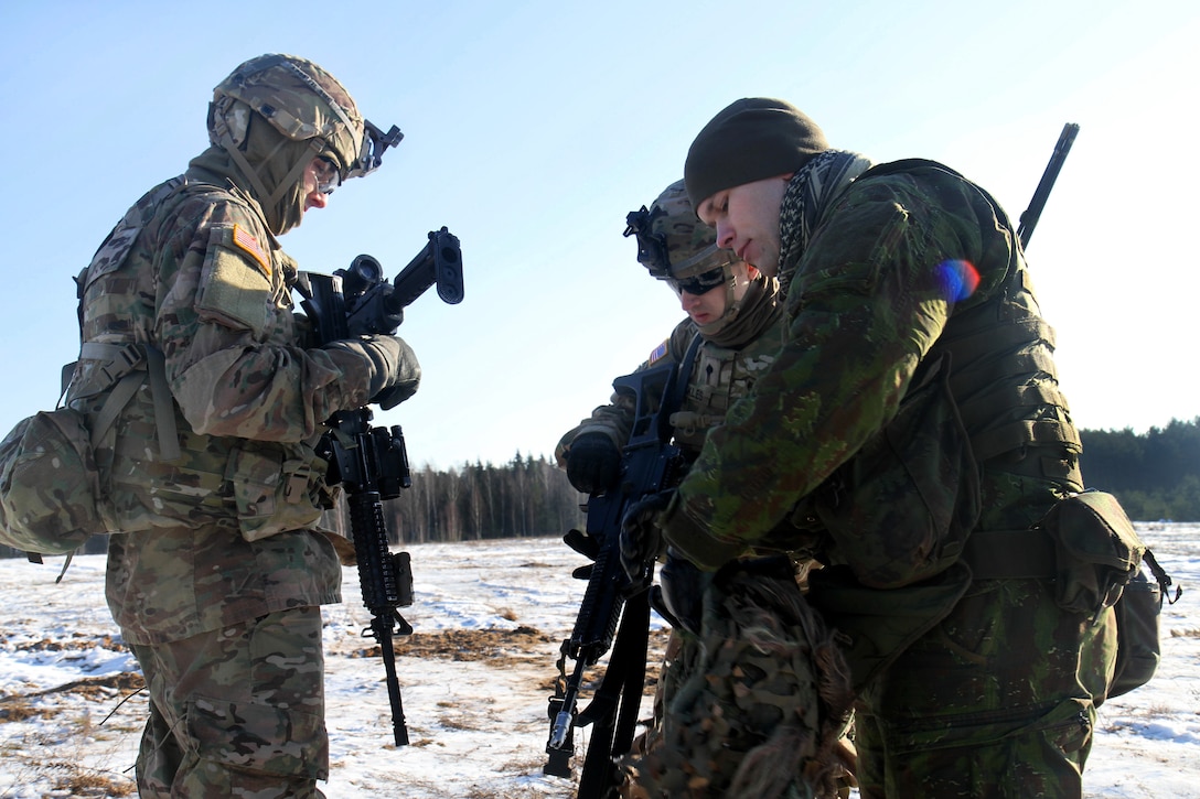 A Lithuanian soldier, right, explains his weapons operation to U.S. soldiers during a training exercise in Rukla, Lithuania Feb. 2, 2015. The Lithuanian soldier is assigned to the Algirdas Battalion, Iron Wolf Brigade.