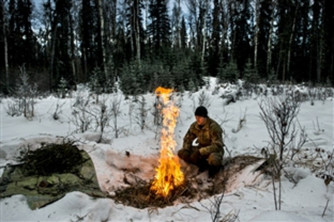 Air Force Staff Sgt. Seth Reab builds a small fire with a pile of tender branches during Arctic Survival School on Eielson Air Force Base, Alaska. Reab is a school instructor assigned to Detachment 1, 66th Training Squadron. 