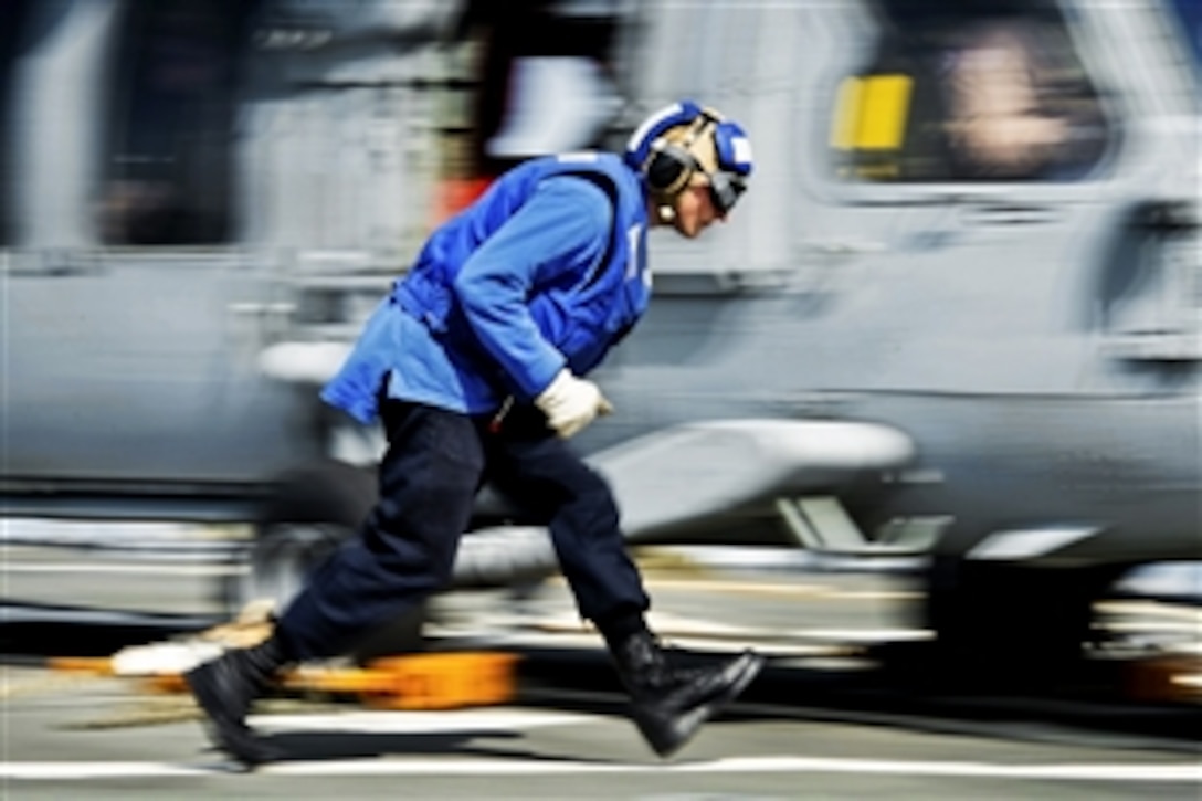 U.S. Navy Seaman Thoren Pond prepares to remove chocks and chains from an MH-60S Seahawk helicopter during flight operations on the guided-missile destroyer USS Mitscher in the Persian Gulf, Jan. 31, 2015. The Mitscher is supporting Operation Inherent Resolve, which includes strike operations in Iraq and Syria as directed.