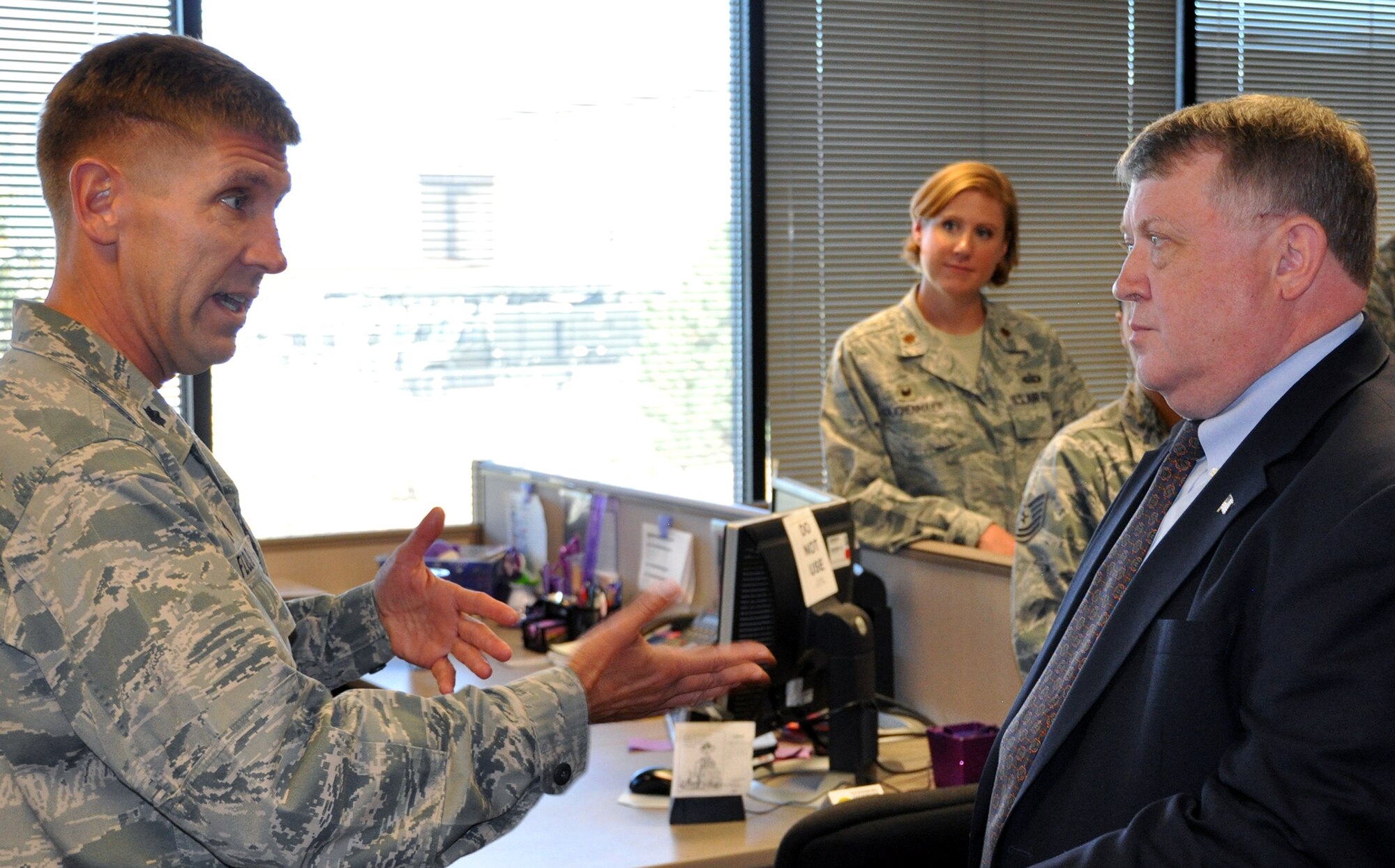 Lt. Col. Alan Flolo talks with Jeffrey Mayo, Deputy Assistant Secretary of the Air Force for Force Management Integration, during Mayo’s visit to the 302nd Airlift Wing and 21st Space Wing Force Support Squadrons Sept. 23, 2014 here. Mayo stopped by the squadrons to get a firsthand look of the integration of the two offices and to find out how the collocation was working. The initial phase of the integration was completed Nov. 1, 2013. Flolo is the 302nd FSS commander. (U.S. Air Force file photo/Master Sgt. Daniel Butterfield)