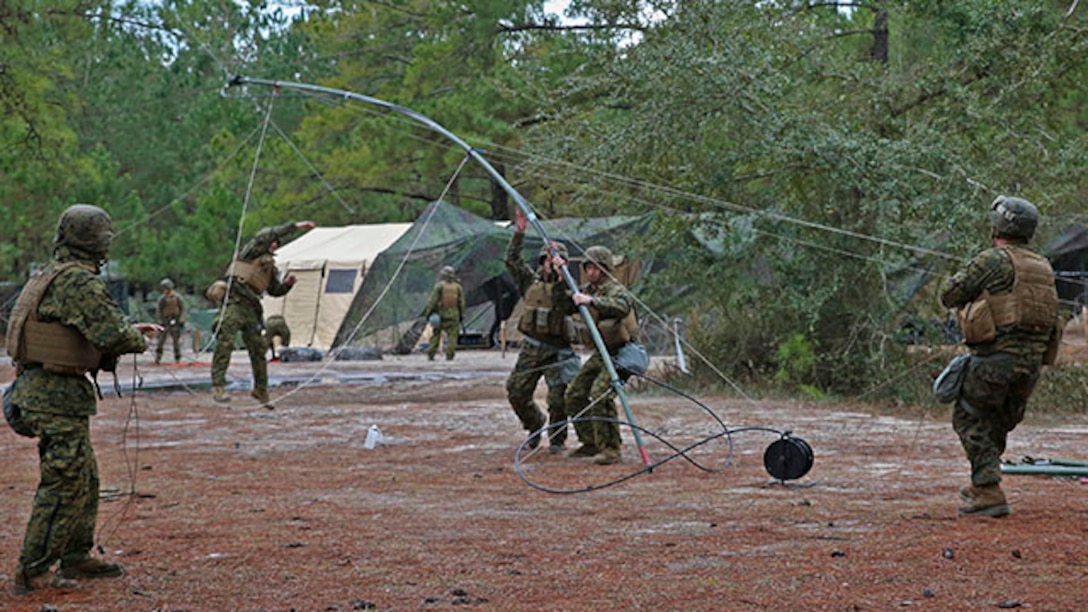 Marines with 2nd Assault Amphibian Battalion set up a communication antenna during a week-long field exercise aboard Camp Lejeune, N.C., Jan 24, 2015. The unit encountered obstacles to its operations with heavy rain, low temperatures and attacks by insurgent role-players, which made constant communication more difficult and more important.