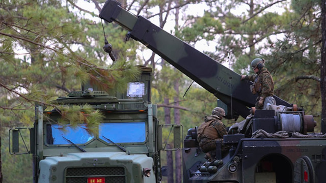 Marines with 2nd Assault Amphibian Battalion prepare to move a container from a Medium Tactical Vehicle Replacement with an Assault Amphibious Vehicle-mounted crane during a week-long field exercise aboard Camp Lejeune, N.C., Jan. 24, 2015. The exercise gave Marines new to the unit insight into how the battalion operates and the unit's role on deployments and in combat.