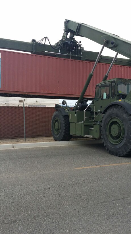 PFC Paul A. Costilla, an embark specialist coordinates the movement of two 40ft ISO containers for Headquarters Company,  MCCES.  