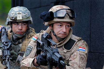 Croatian and Minnesota National Guard Soldiers prepare to clear a room during an Operational Mentoring and Liaison Team training exercise at the Joint Multinational Readiness Center. The U.S. and multinational troops will deploy together to Afghanistan as part of the NATO International Security Assistance Force. The OMLT will help with the ISAF mission of assisting the Government of Afghanistan in establishing and maintaining a safe and secure environment.