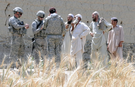 Elders from the village of Chure Khel in eastern Afghanistan's Nangarhar province interrupt their daily routine May 1 to talk to U.S. Army Staff Sgt. Jason P. Ites and Master Sgt. Don K. Lilleman with the Missouri Agribusiness Development Team in Nangarhar Province as the Soldiers take notes next to the community's wheat fields. The Nangarhar ADT visits communities throughout the province to check on government projects and discuss community needs.